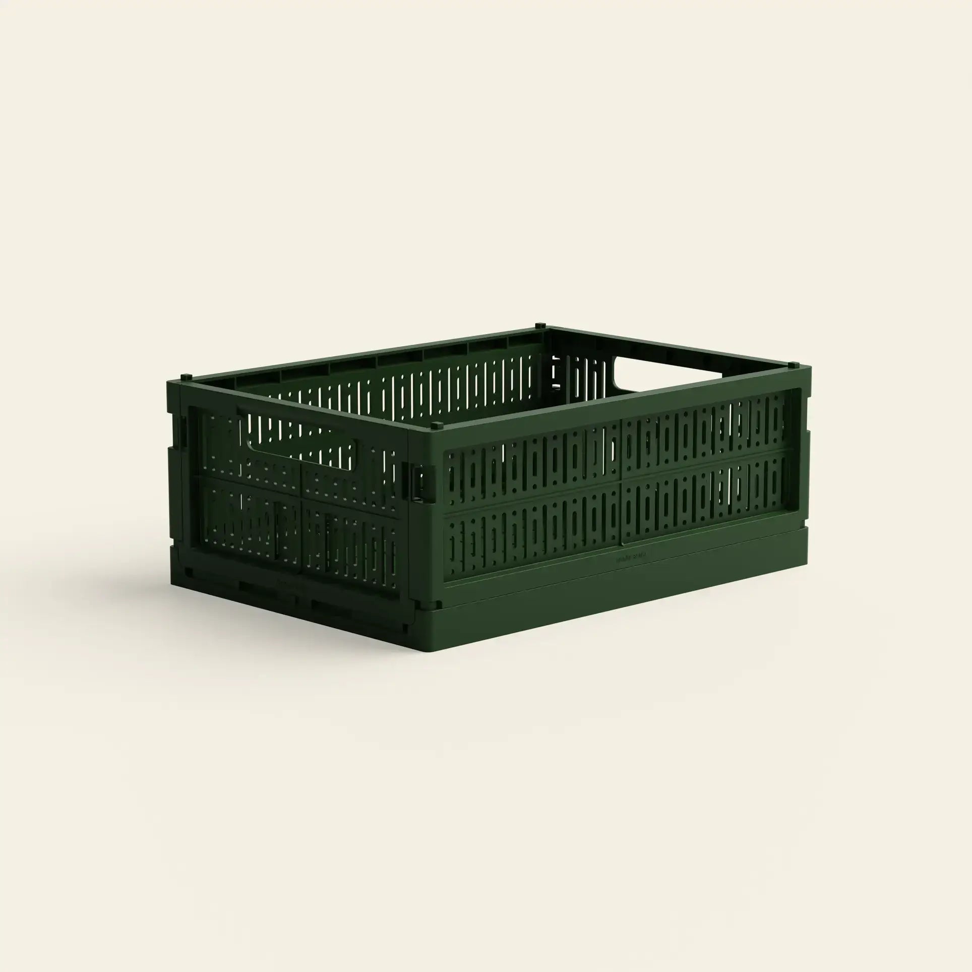 The Made Crate Midi by Made Crate is a dark green, rectangular storage crate crafted from recycled plastic, with slotted sides and stacking handles, shown on a simple, light background.