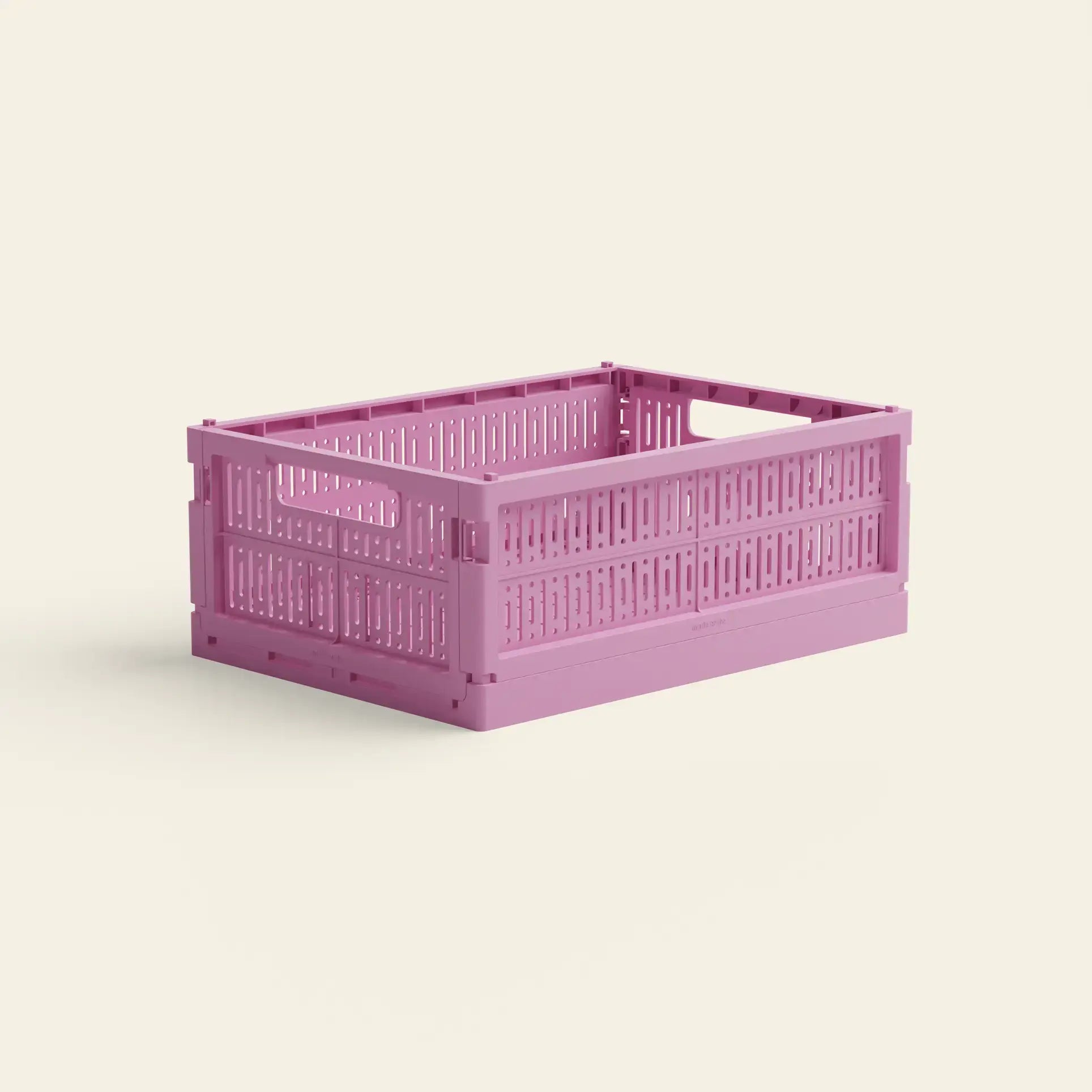 The Made Crate Midi by Made Crate is a pink recycled plastic storage crate with open slats and handles for easy stacking, shown against a plain light background.
