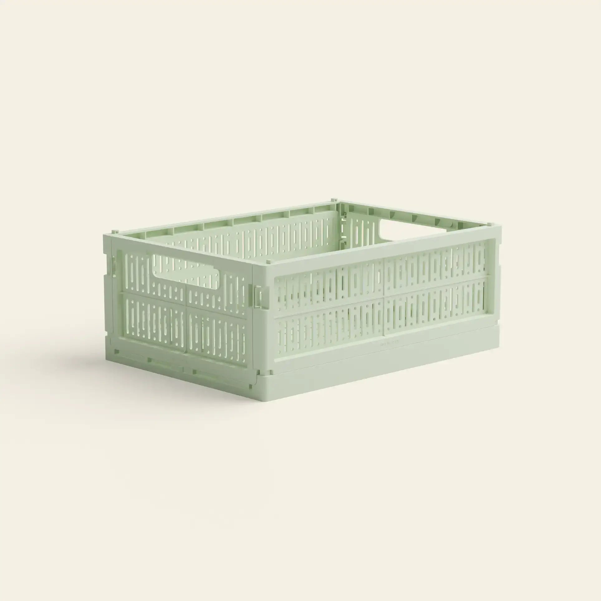 The Made Crate Midi by Made Crate is a light green, rectangular storage crate made from recycled plastic with open slatted sides and stacking handles, shown on a plain light background.