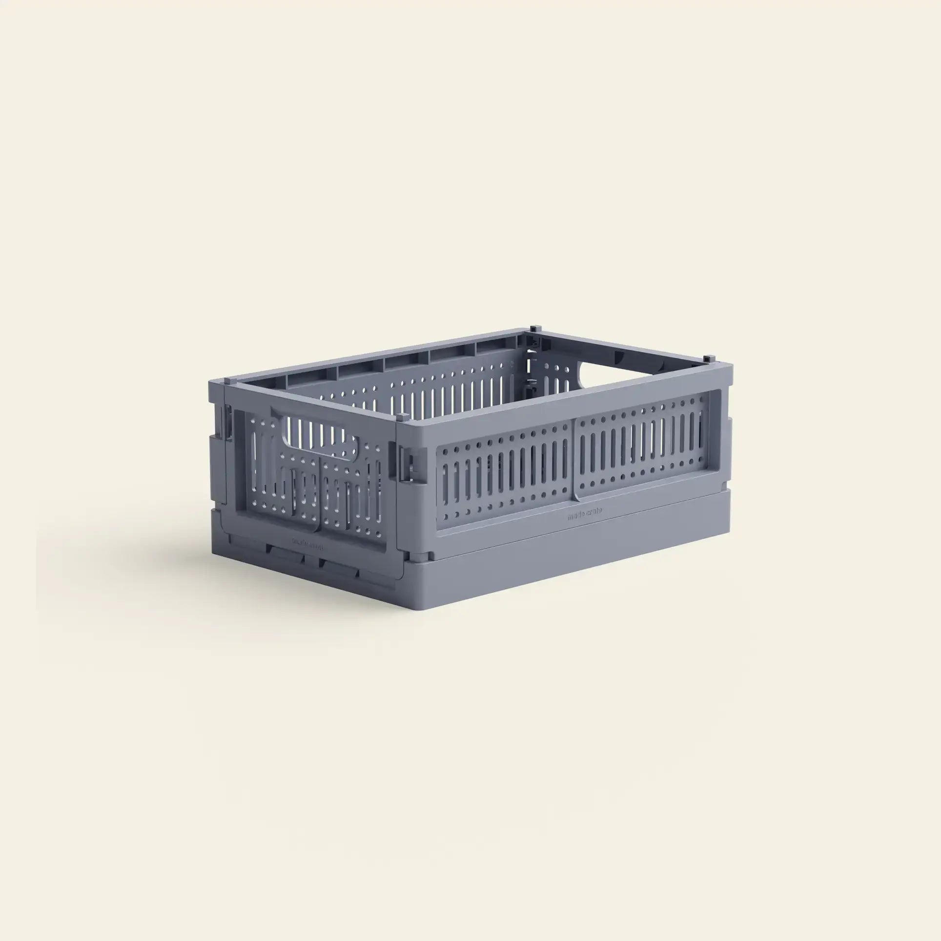 The Made Crate Mini by Made Crate is a gray, rectangular storage crate with slotted sides and a solid base, made from recycled plastic for eco-friendly stacking convenience.