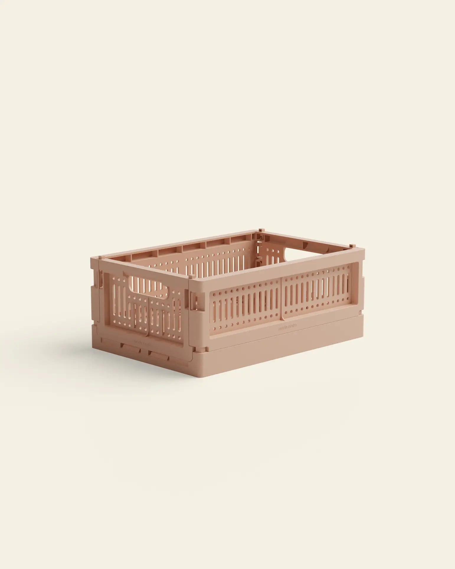 The Made Crate Mini by Made Crate is a light brown, rectangular storage crate with slotted sides and an open top, crafted from recycled plastic for eco-friendly stacking, shown on a light cream background.