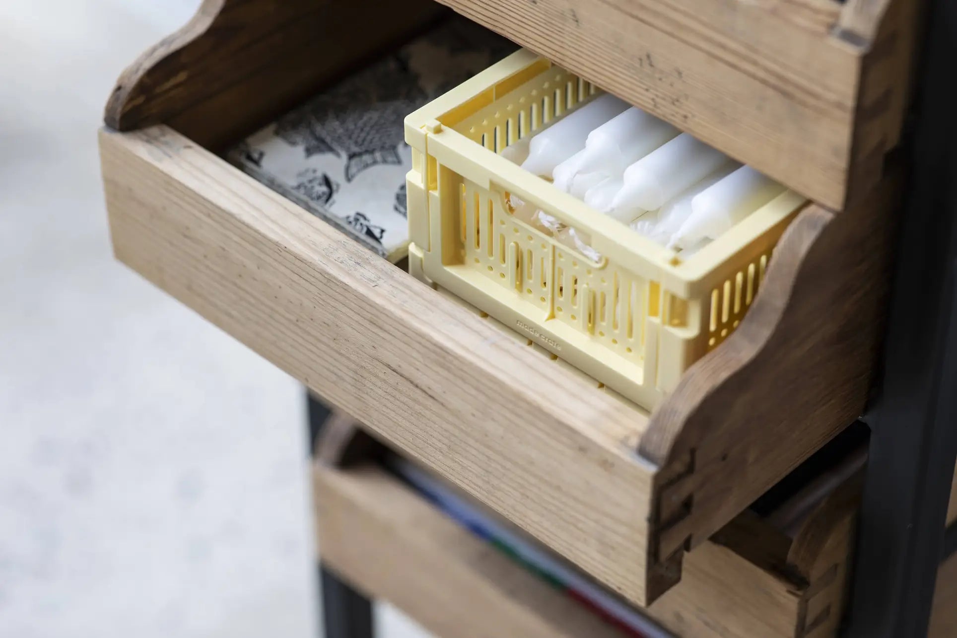 A wooden drawer is partially open, revealing a yellow Made Crate Mini by Made Crate filled with neatly arranged white tampons for organized, stackable storage.