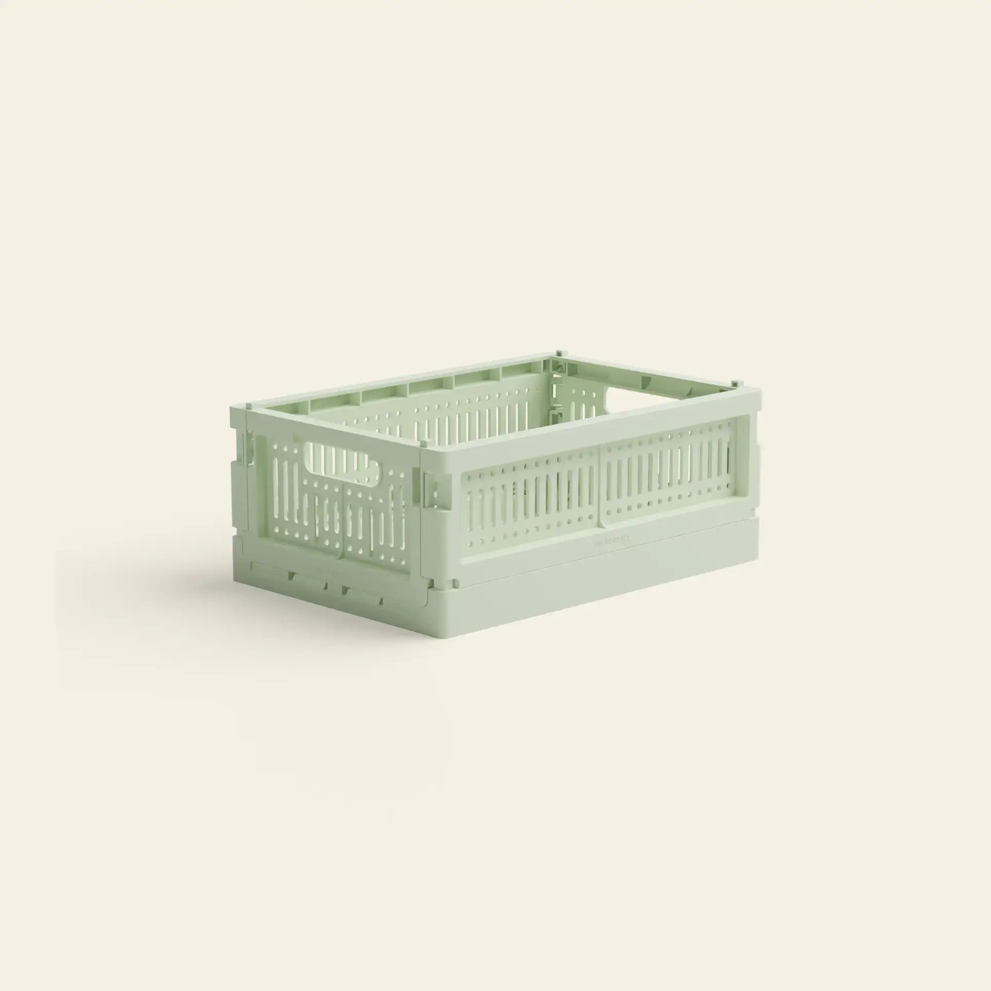 The Made Crate Mini by Made Crate is a light green, rectangular storage crate with slotted sides and handles, crafted from recycled plastic. It is displayed on a plain off-white background.