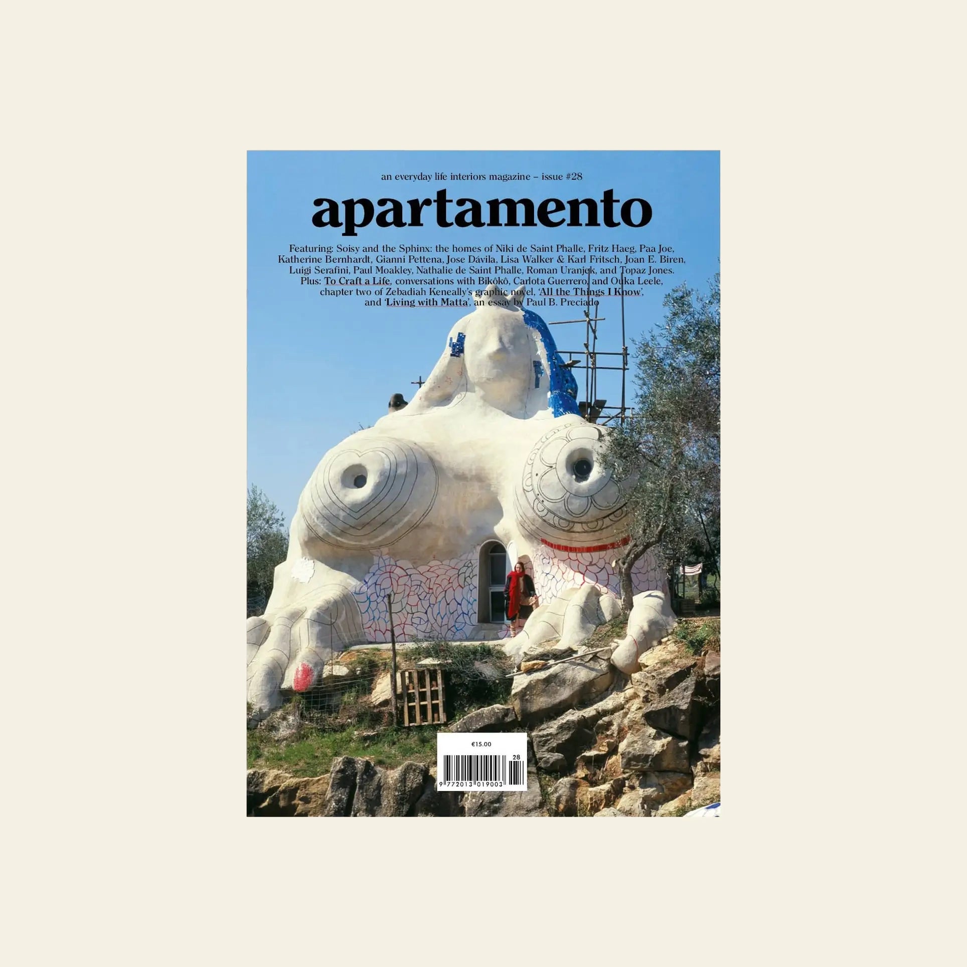 The cover of Apartamento Magazine Issue #28 features a unique white dome house inspired by Niki de Saint Phalle, with sculpted breasts and eyes, a ladder, and building materials among trees.