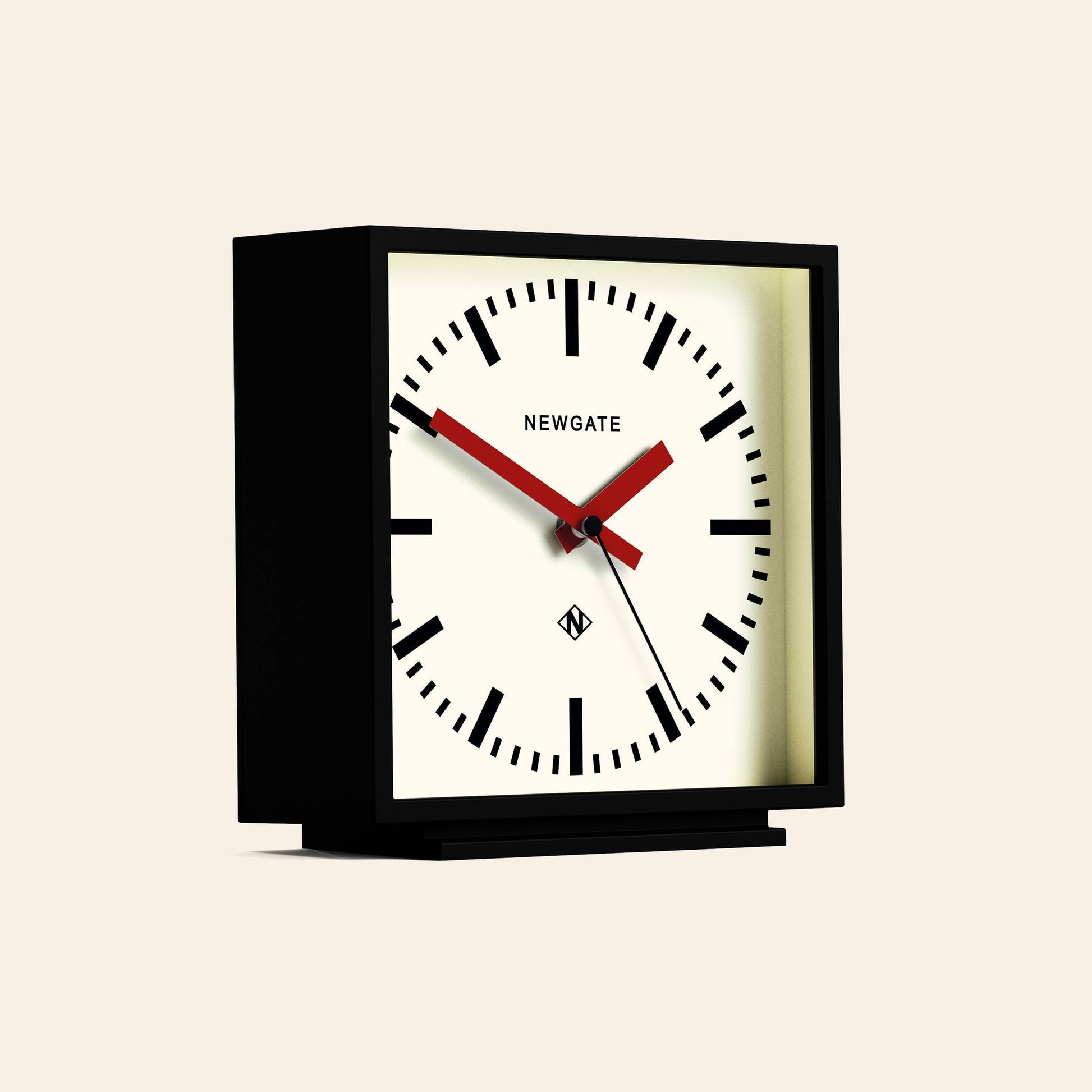 The Newgate Amp Mantel Clock is a modern square black clock featuring bold black markers, station style, red hour and minute hands, a black second hand, and NEWGATE on the face, showing the time as 10:09:36.