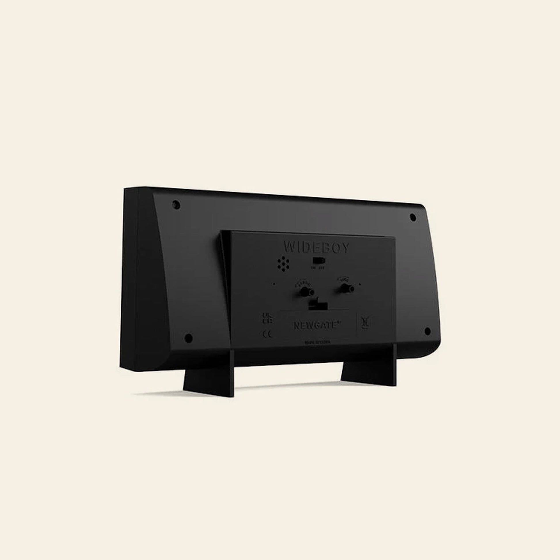 Rear view of the Newgate Wideboy Alarm Clock by Newgate, a black rectangular retro-style alarm clock with two support legs and detailed ports, labels, and text on its back, displayed on a plain beige background.