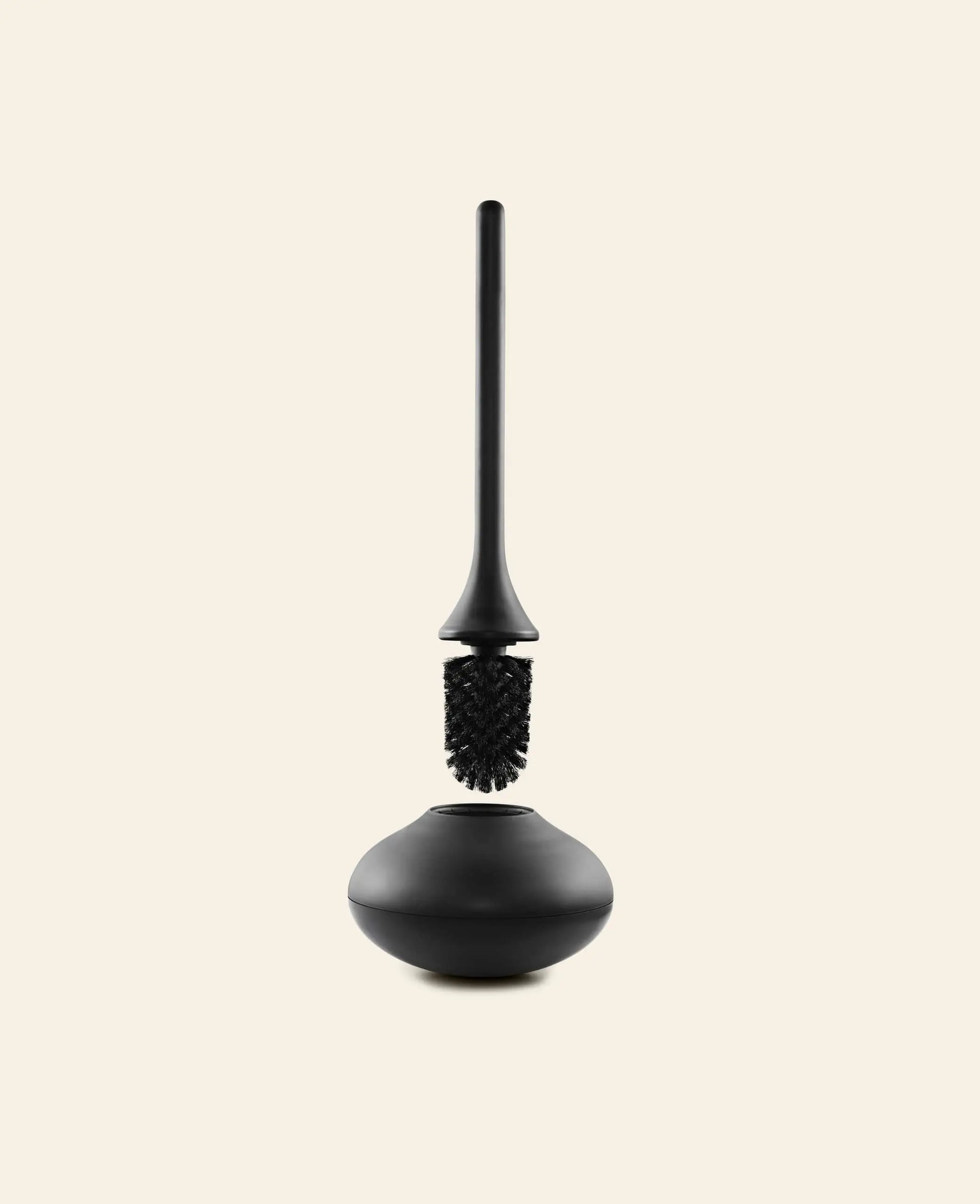 A Normann Copenhagen Ballo Toilet Brush in black, with matching holder, is shown upright on a plain light beige background.