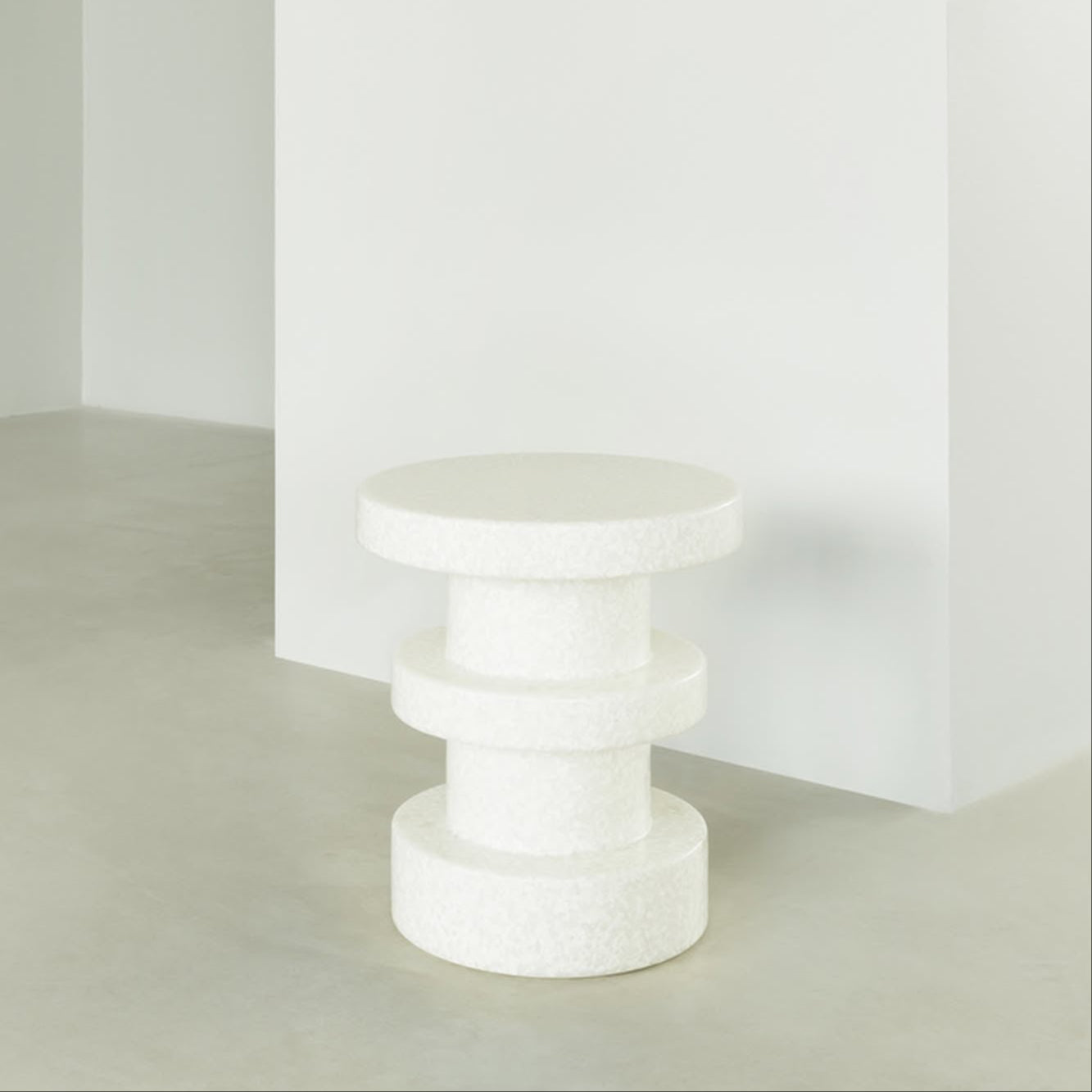 The Normann Copenhagen Bit Stool Stack features a modern, white textured geometric design with stacked cylindrical shapes, offering multifunctional and versatile seating for minimalist interiors.