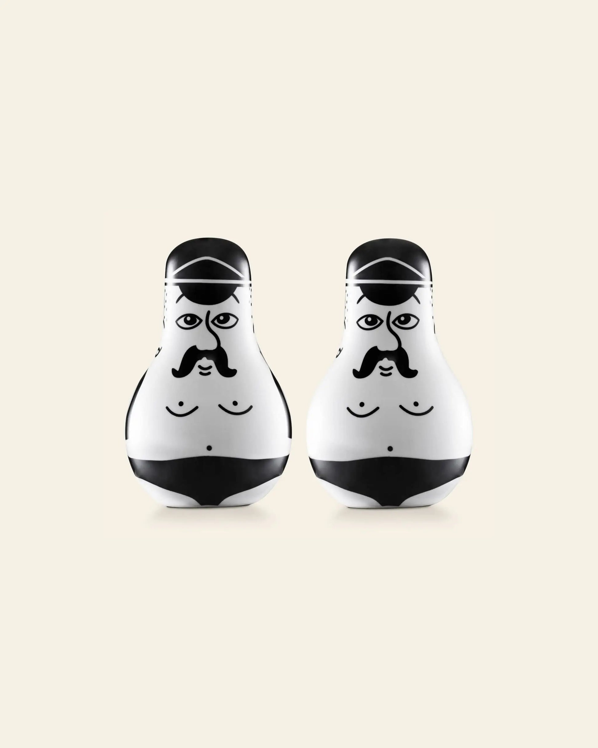 The Normann Copenhagen Friends Salt & Pepper Set features two white, egg-shaped figurines with cartoon faces, black mustaches, and swimsuits—a fun gift for fans of playful design by Normann Copenhagen.