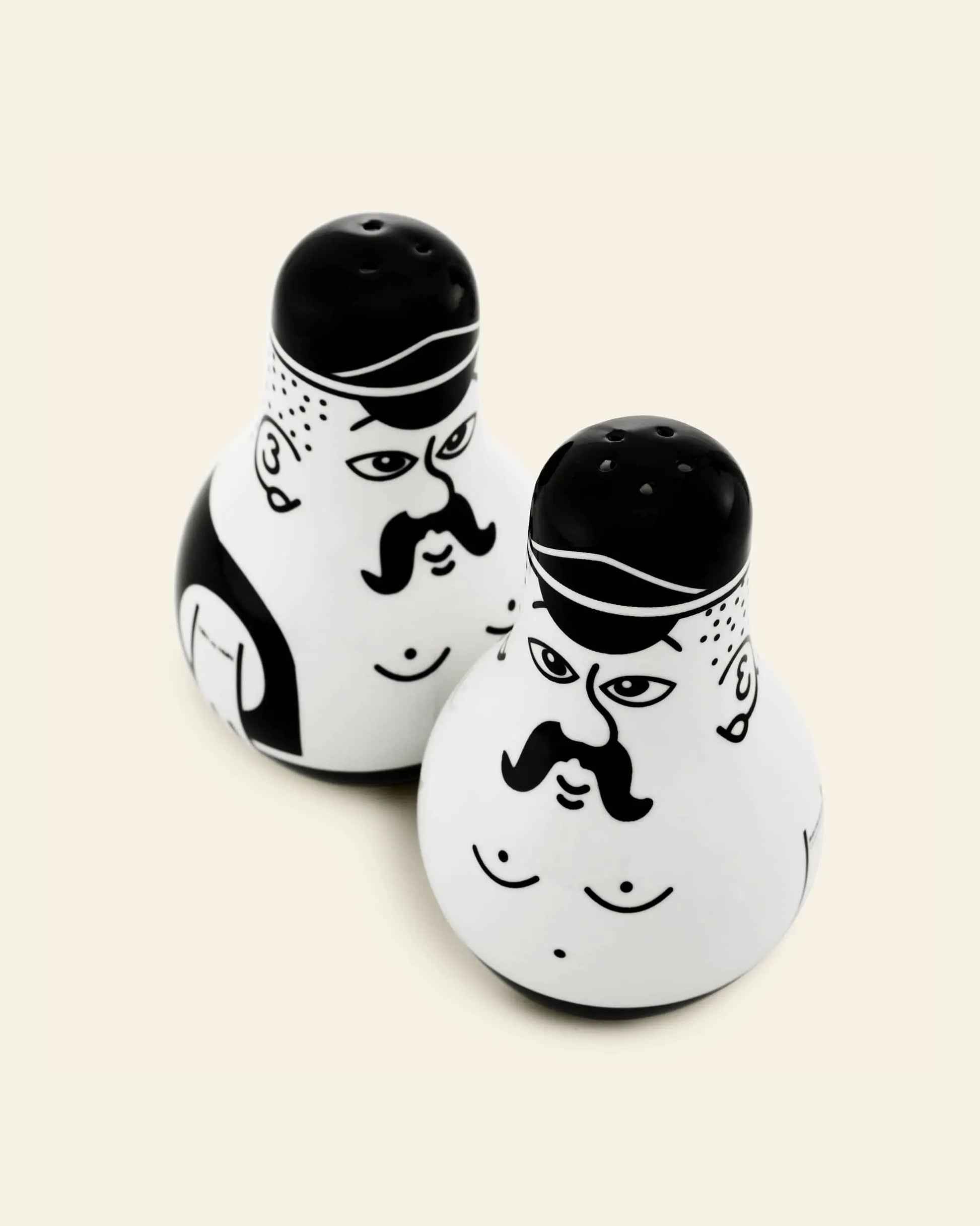 The Normann Copenhagen Friends Salt & Pepper Set features two ceramic shakers shaped like stylized men, accented by minimal black illustrations—a unique and eye-catching gift for design enthusiasts.