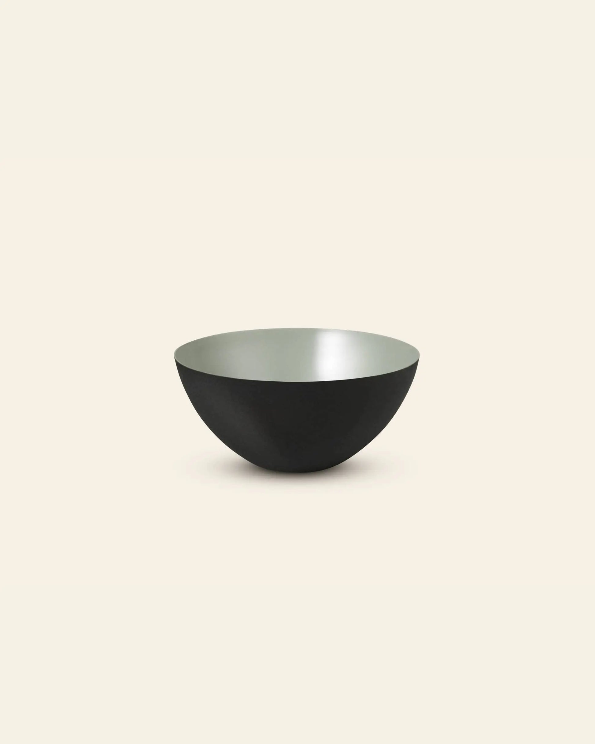 The Normann Copenhagen Krenit Bowl (12.5cm) features Danish minimalist design with a matte black exterior and smooth light gray interior, shown against an off-white background.