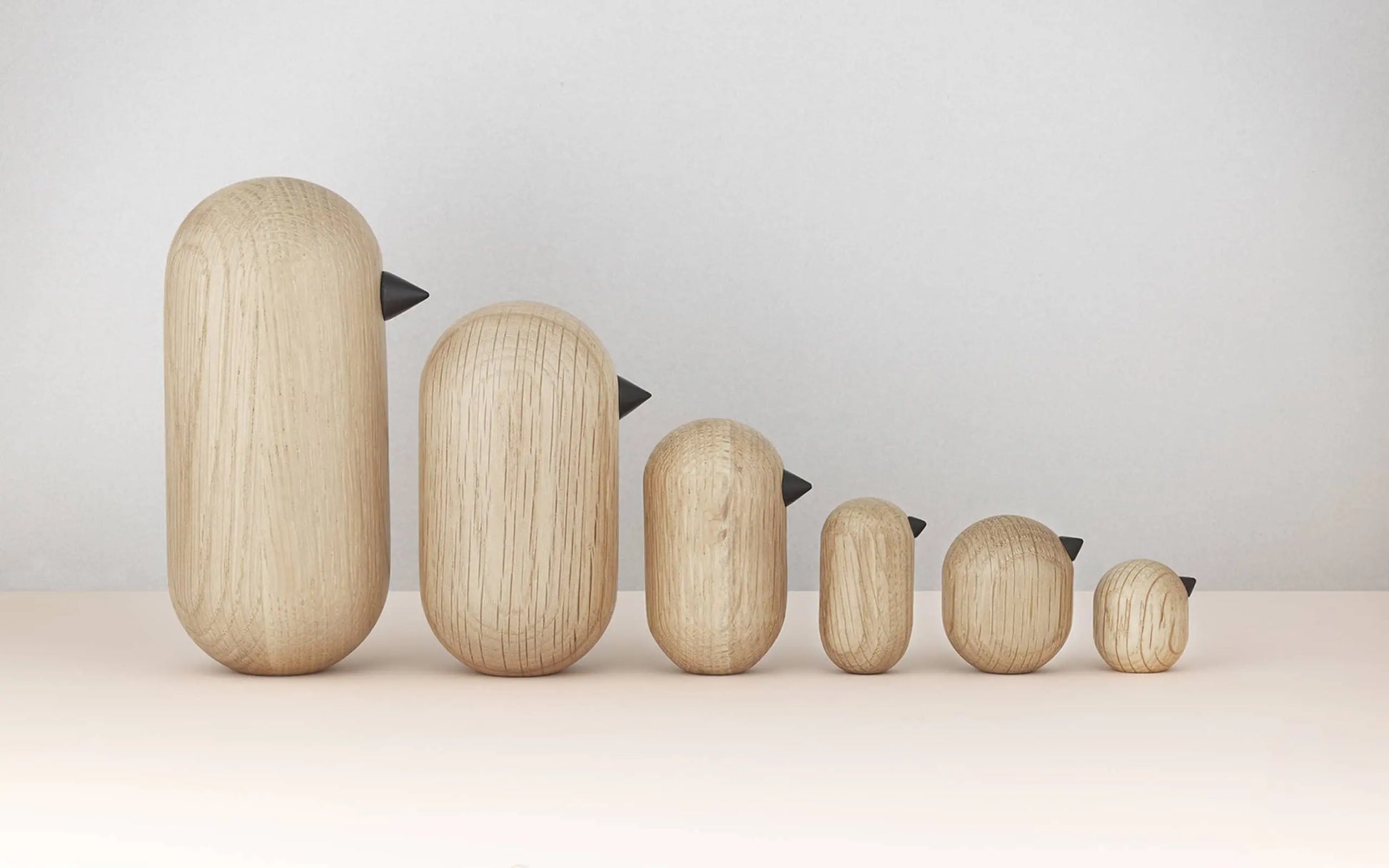 The Normann Copenhagen Little Bird, 7cm, features a simple oval shape and small black beak—its minimalist design adds a stylish touch to any neutral-themed home decor.