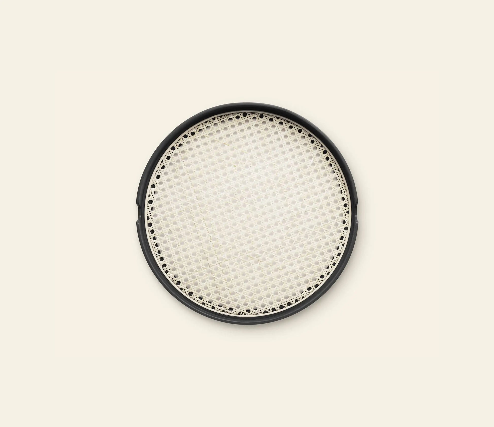 The Normann Copenhagen Salon Tray, 40cm, features a round black frame and woven cream mesh center, resembling a decorative serving piece by Normann Copenhagen, shown against a light beige background.