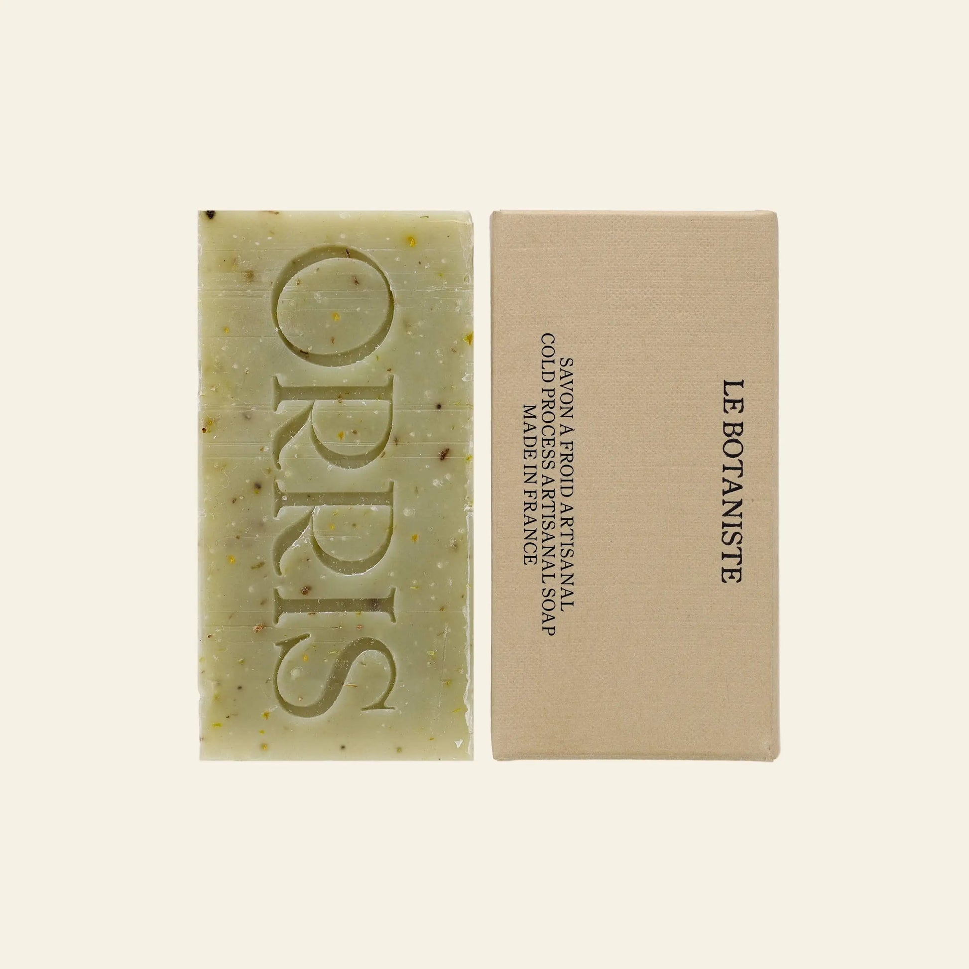 ORRIS Le Botaniste is a natural, handcrafted botanical soap by ORRIS. Made in France, it features visible calendula and botanicals, and comes with beige LE BOTANISTE packaging. ORRIS is engraved on the artisanal bar.