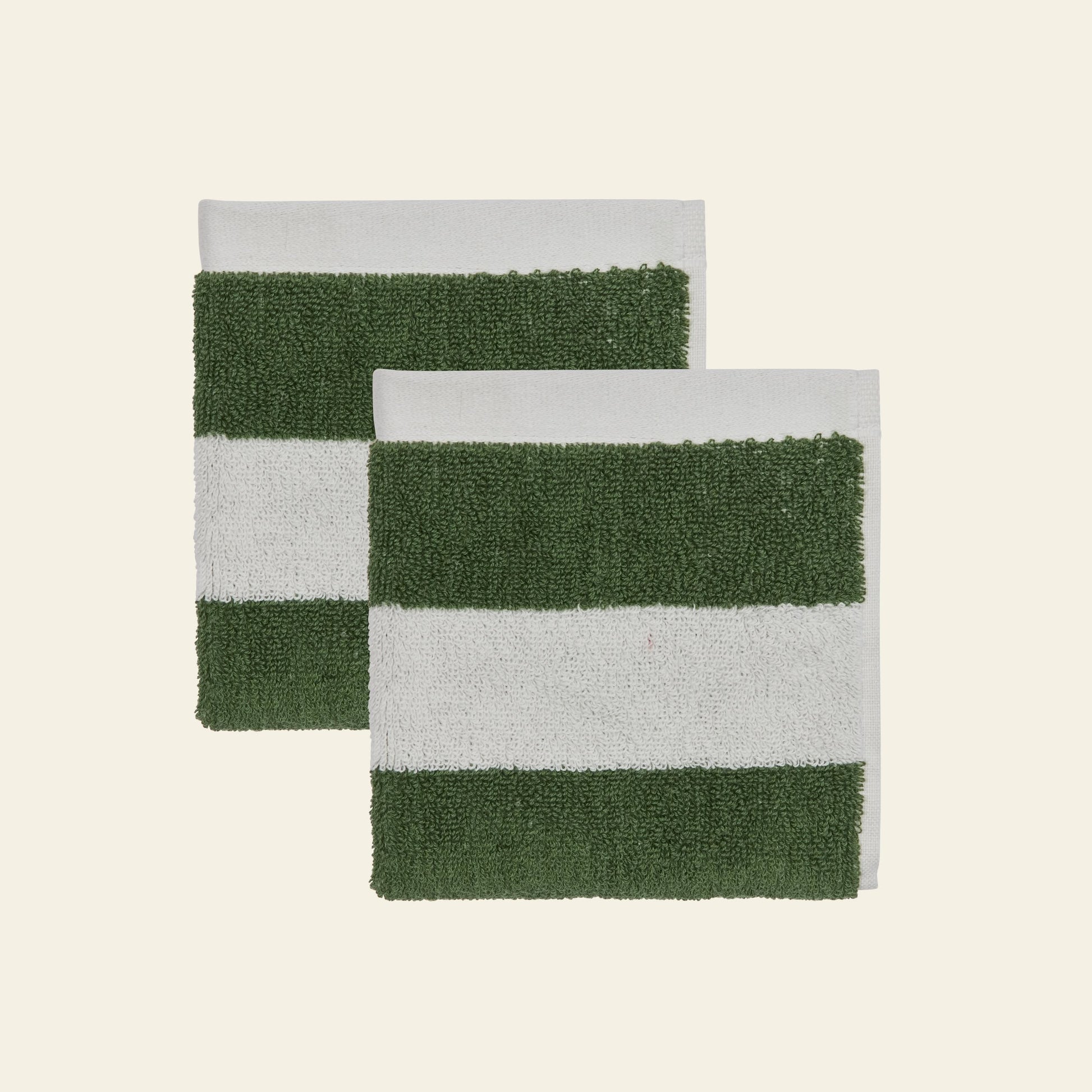 Two overlapping OYOY Living Design Raita Wash Cloths, pack of 2, made from organic cotton terry with green and white stripes, are placed on a light beige background.