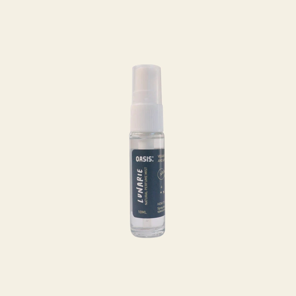 A 10ml clear spray bottle with a white cap and blue label reading Oasis Beauty Kitchen Room and Linen Mist sits on a light beige background. Enjoy fresh linen notes in this perfume-grade mist by Oasis Beauty Kitchen.