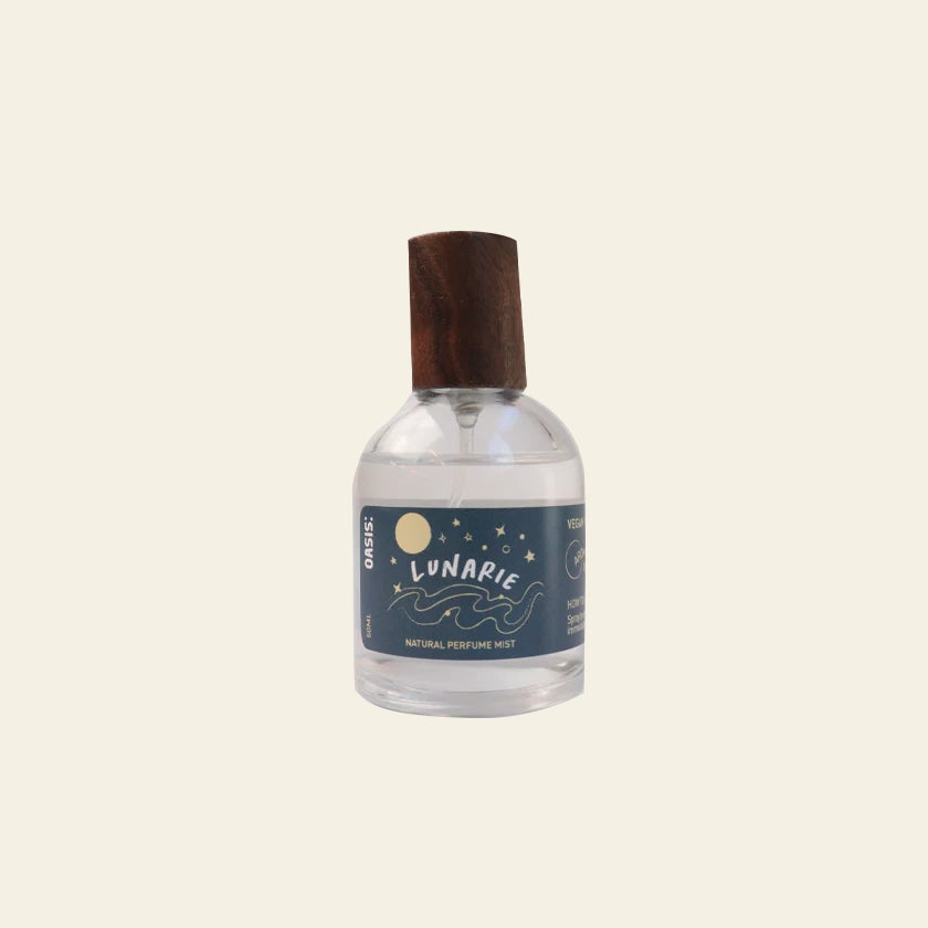 A clear 50ml glass bottle of Oasis Beauty Kitchen Room and Linen Mist features a blue lunar-themed label and a wooden cap. Set on a plain background, it delivers a fresh linen scent, ideal for refreshing rooms or fabrics.