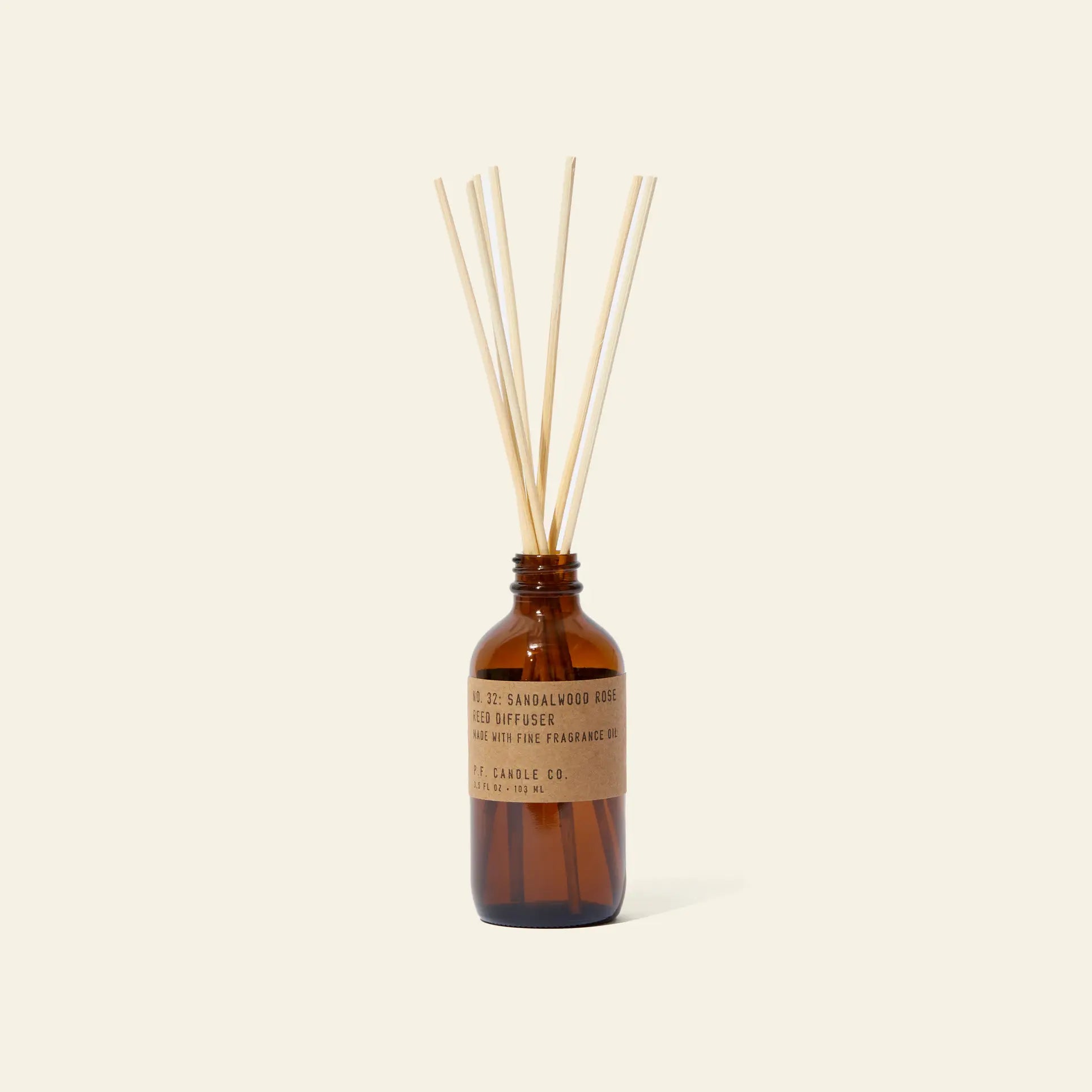 A P.F. Candle Co. 3.5oz Reed Diffuser in Sandalwood Rose stands upright with natural reed sticks on a light background, inviting you to enjoy its signature aromatic scent.