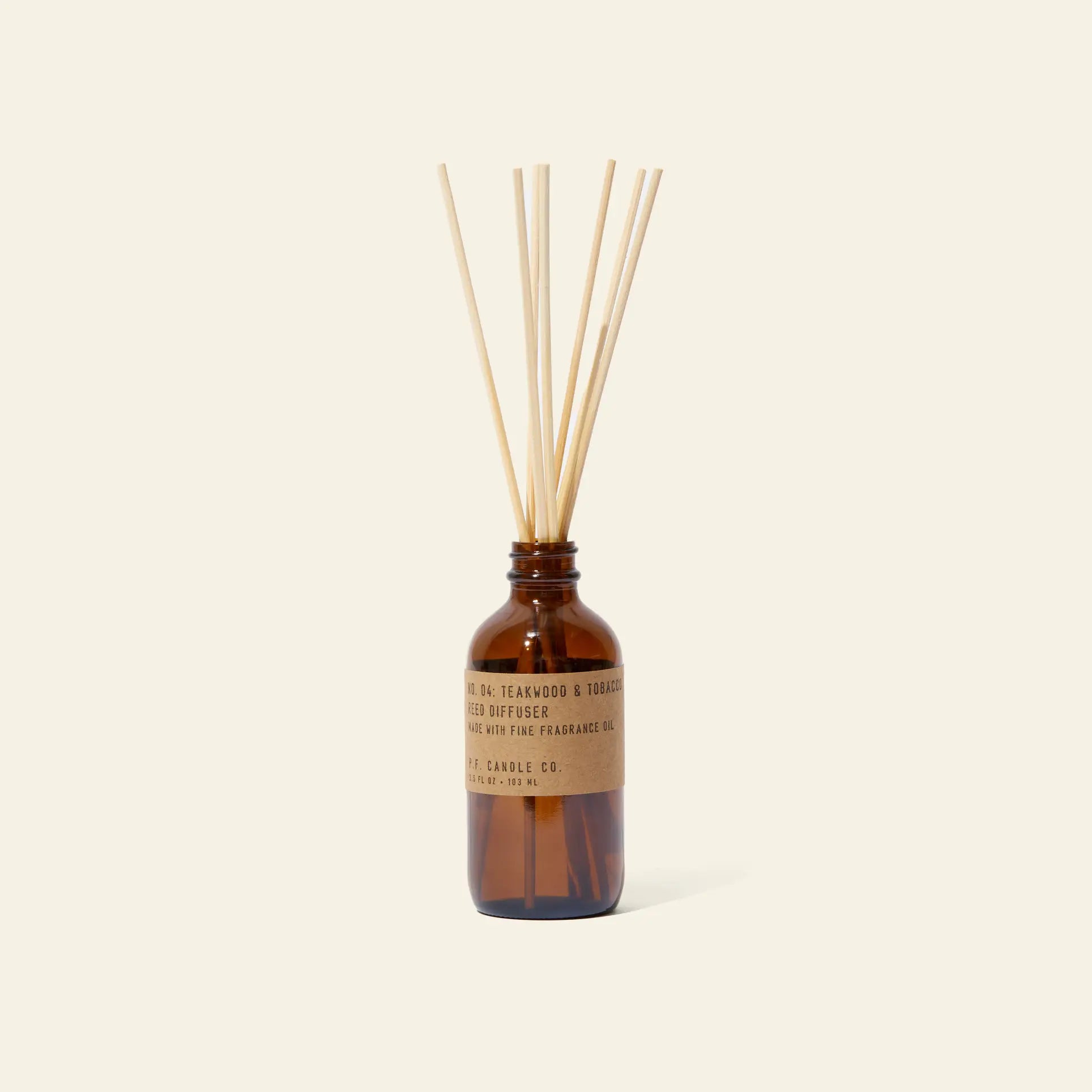 The P.F. Candle Co. 3.5oz Reed Diffuser in Teakwood & Tobacco features a brown glass bottle with kraft label and diffuser sticks—an elegant way to enjoy signature scents and quality fragrance oils in your space.
