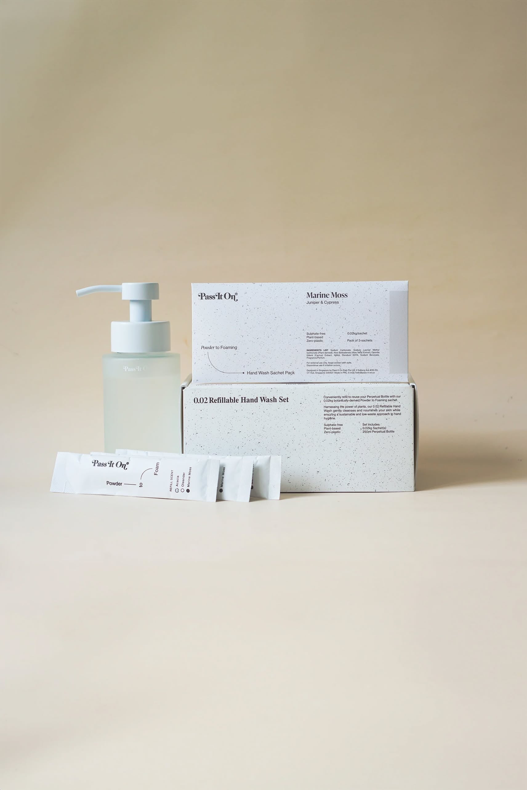 Pass It On 0.02 Refillable Hand Wash Set, Pack of 3-Marine Moss by Pass It On includes a frosted pump bottle, refill packets, and product box—all on a neutral beige background—featuring the fresh scent of Marine Moss.