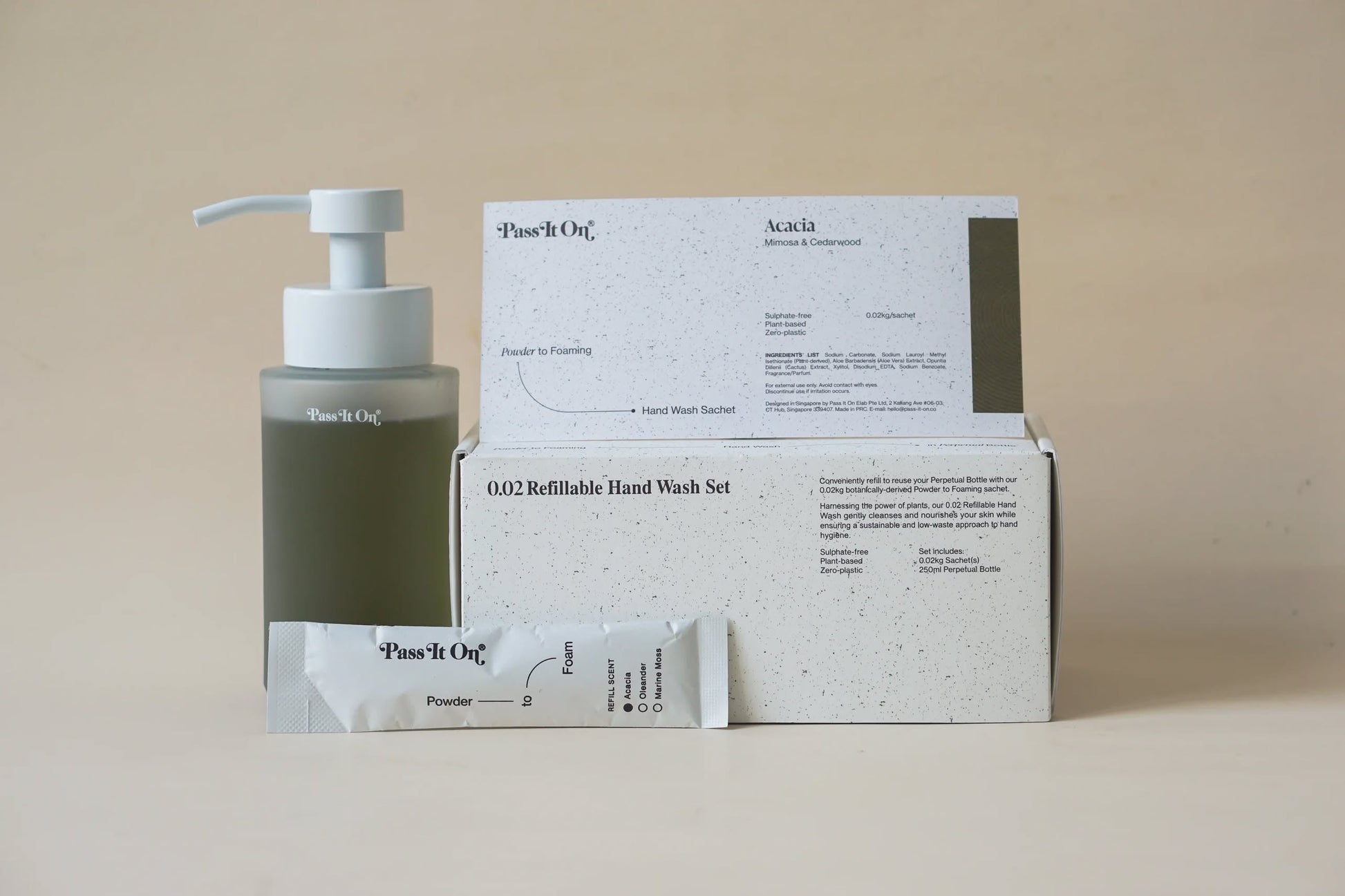 Pass It Ons 0.02 Refillable Hand Wash Set in Acacia features a pump bottle, a Powder sachet, and two minimalist boxes from Pass It On, all displayed against a plain beige background.