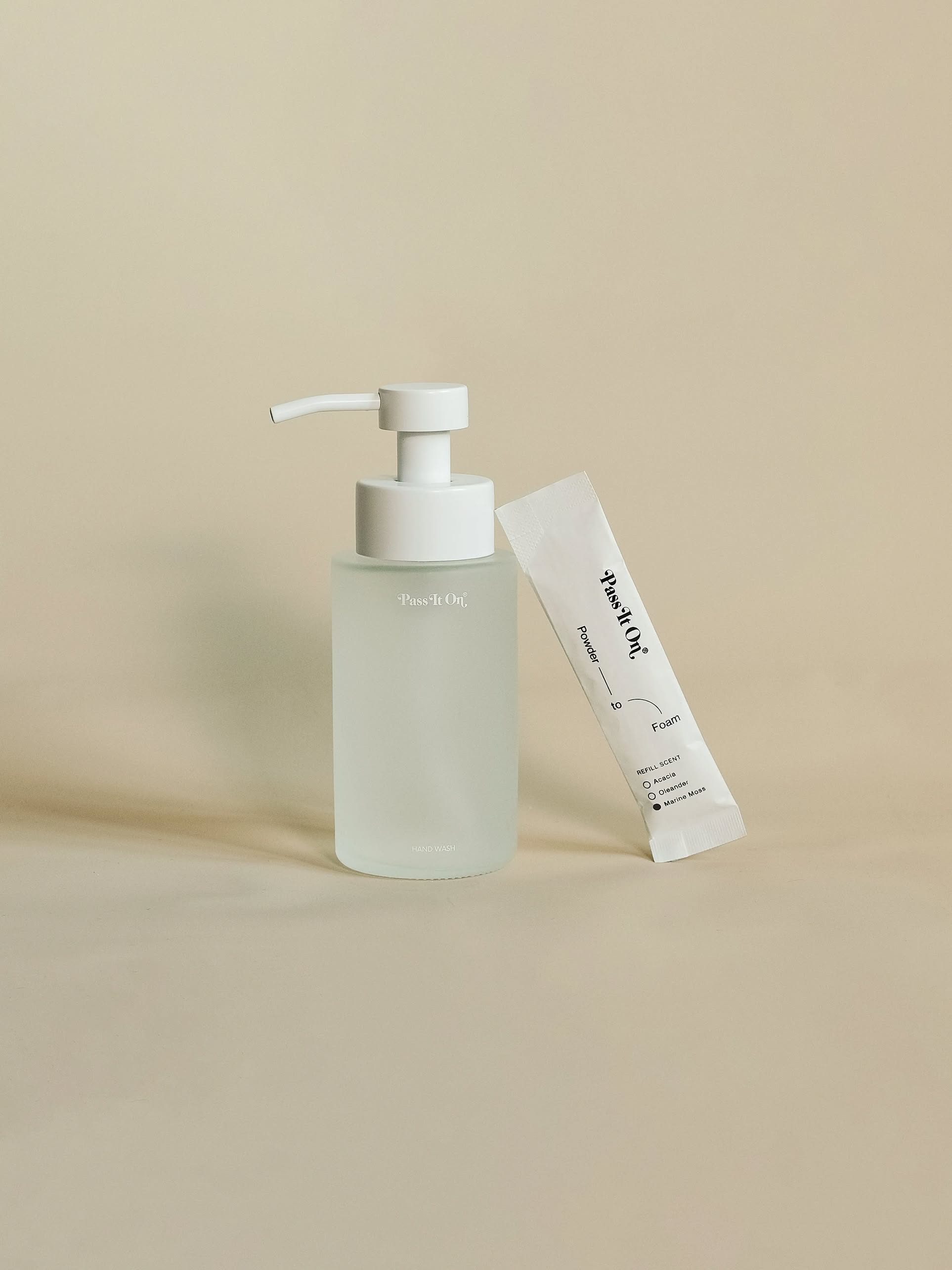 The Pass It On 0.02 Refillable Hand Wash Set in Marine Moss features a frosted glass pump bottle with a white dispenser and a matching sachet, both with minimalistic, modern packaging and subtle branding from Pass It On.