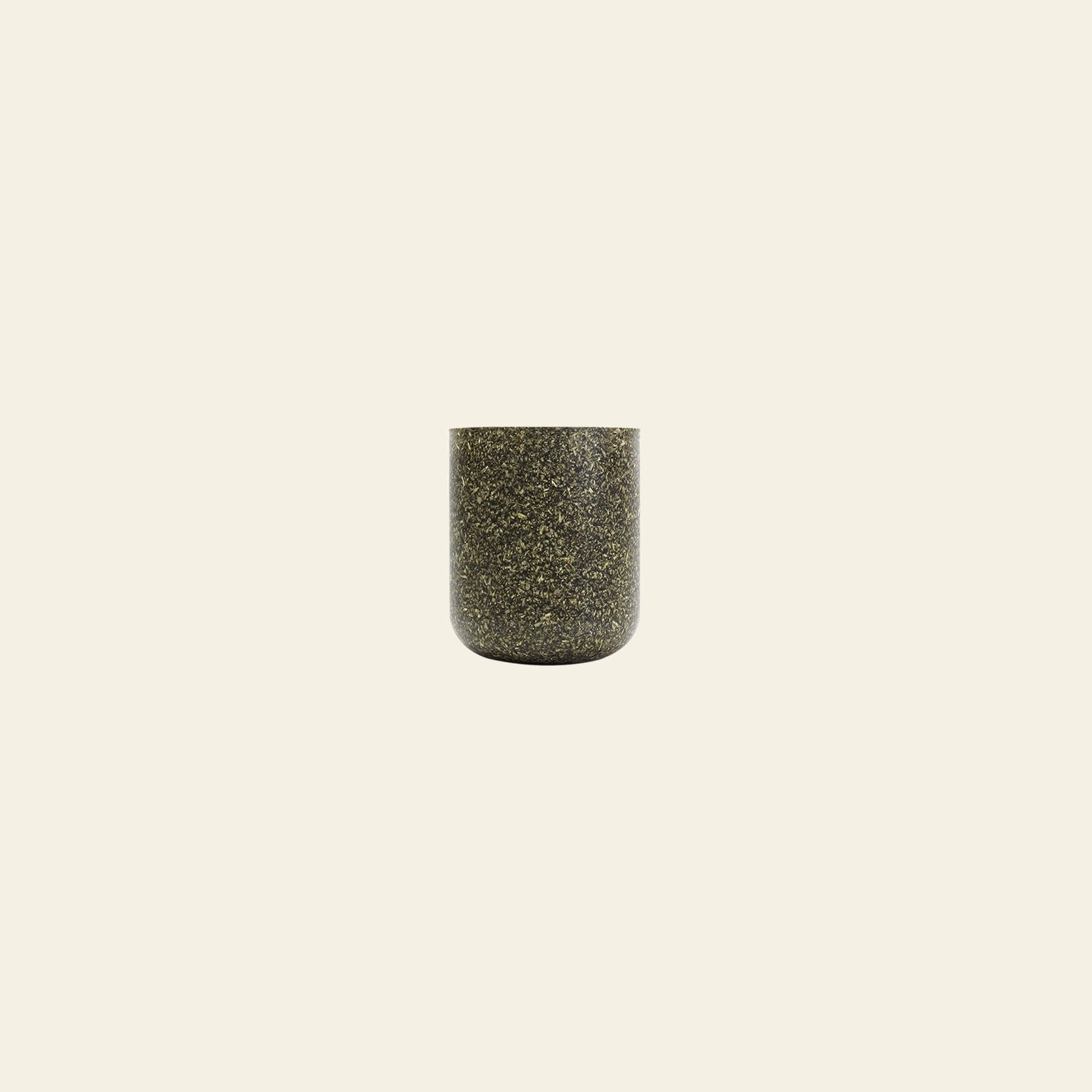 The Pass It On Capsule Cup, Rice Huskâa small, cylindrical cup made from upcycled rice husks with dark specklesâis centered on a plain, light beige background.