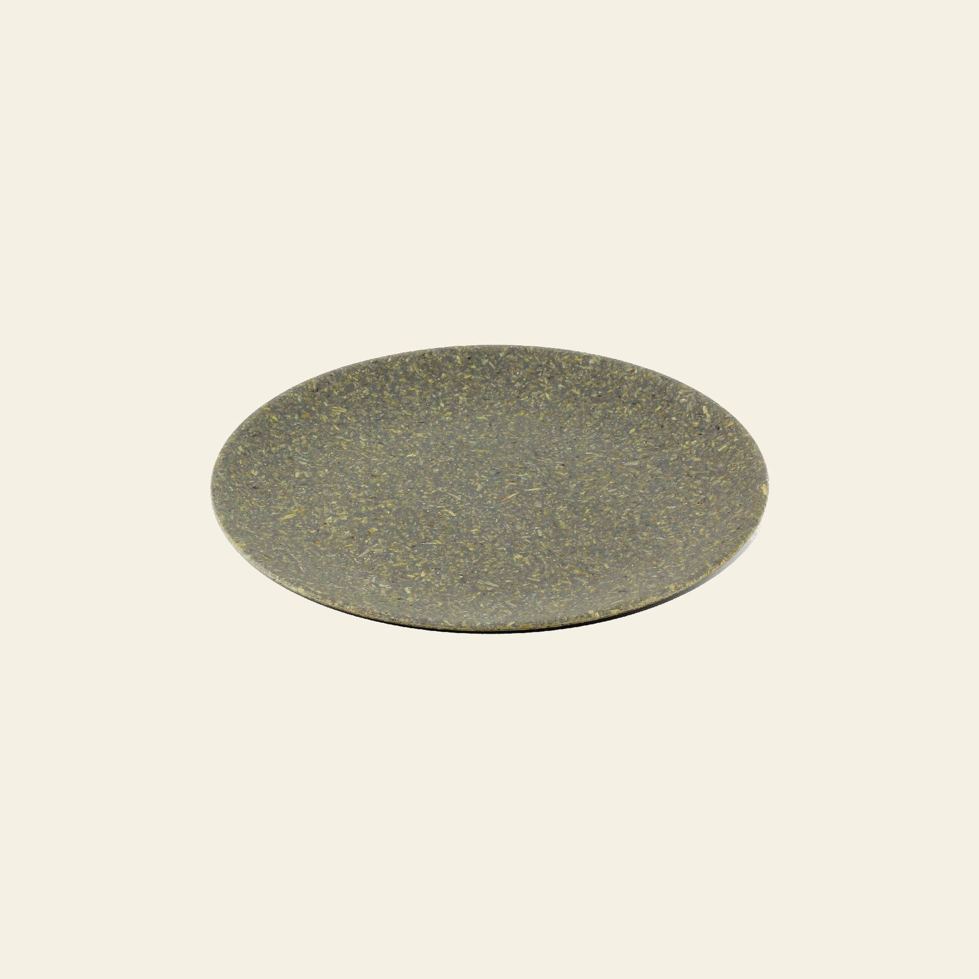 The Pass It On Dining Plate M, Rice Husk by Pass It On is a sustainable, round, flat plate in dark greenish-brown with a smooth texture, displayed centered on a plain light beige background.