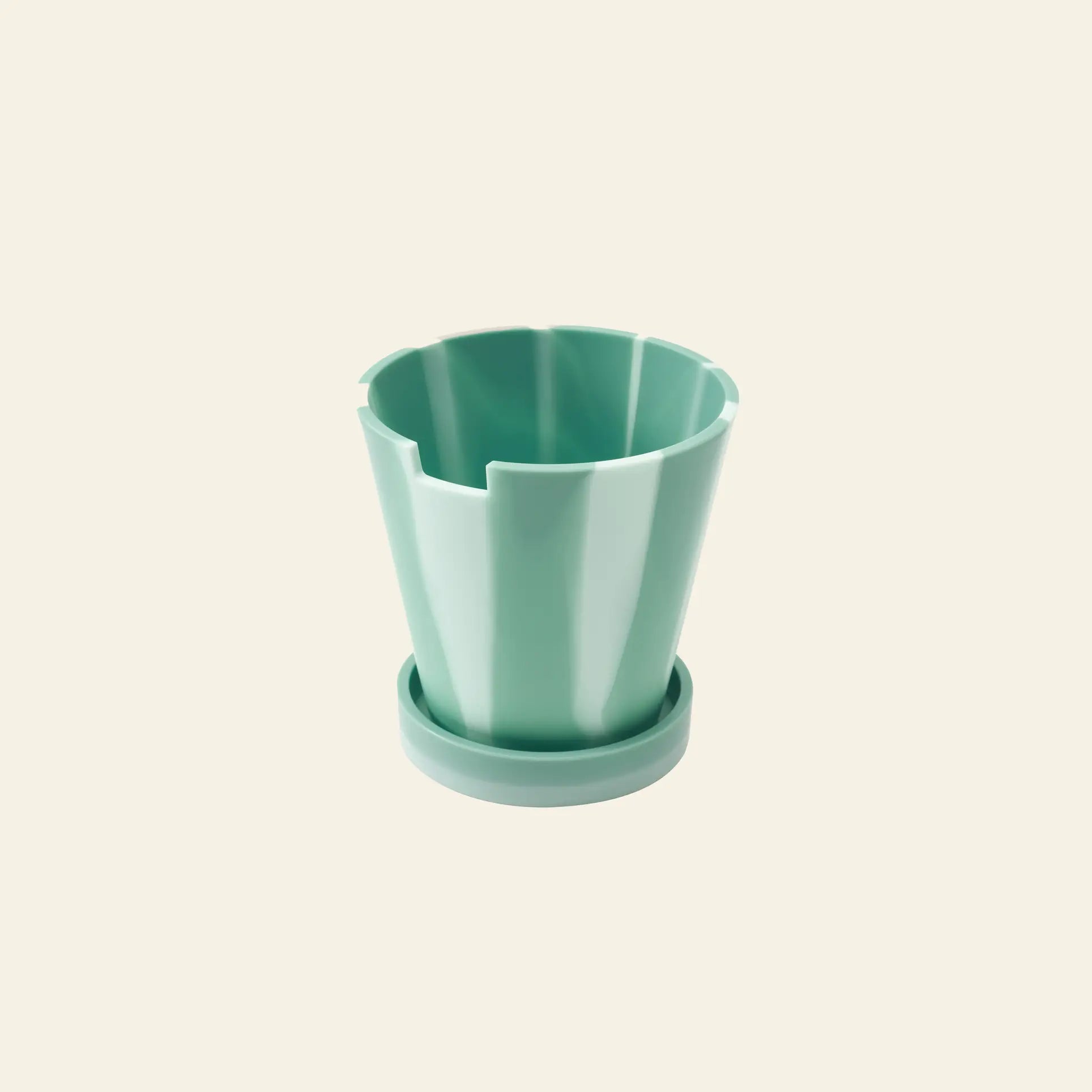 The Plastic Ark Dirty Pot by Plastic Ark is a light green, fluted sustainable plant pot with a matching saucer, shown on a plain beige background.