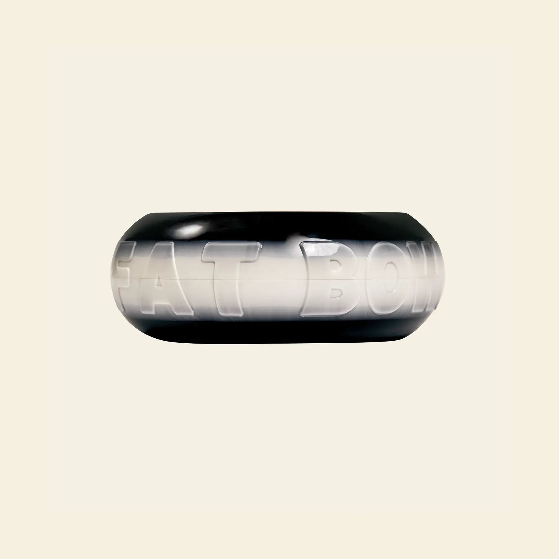 The Plastic Ark Fat Bowl by Plastic Ark is a black and white round plastic pet bowl with “FAT BOWL” embossed on the side, shown on a light beige background. Customize its design to match your style.