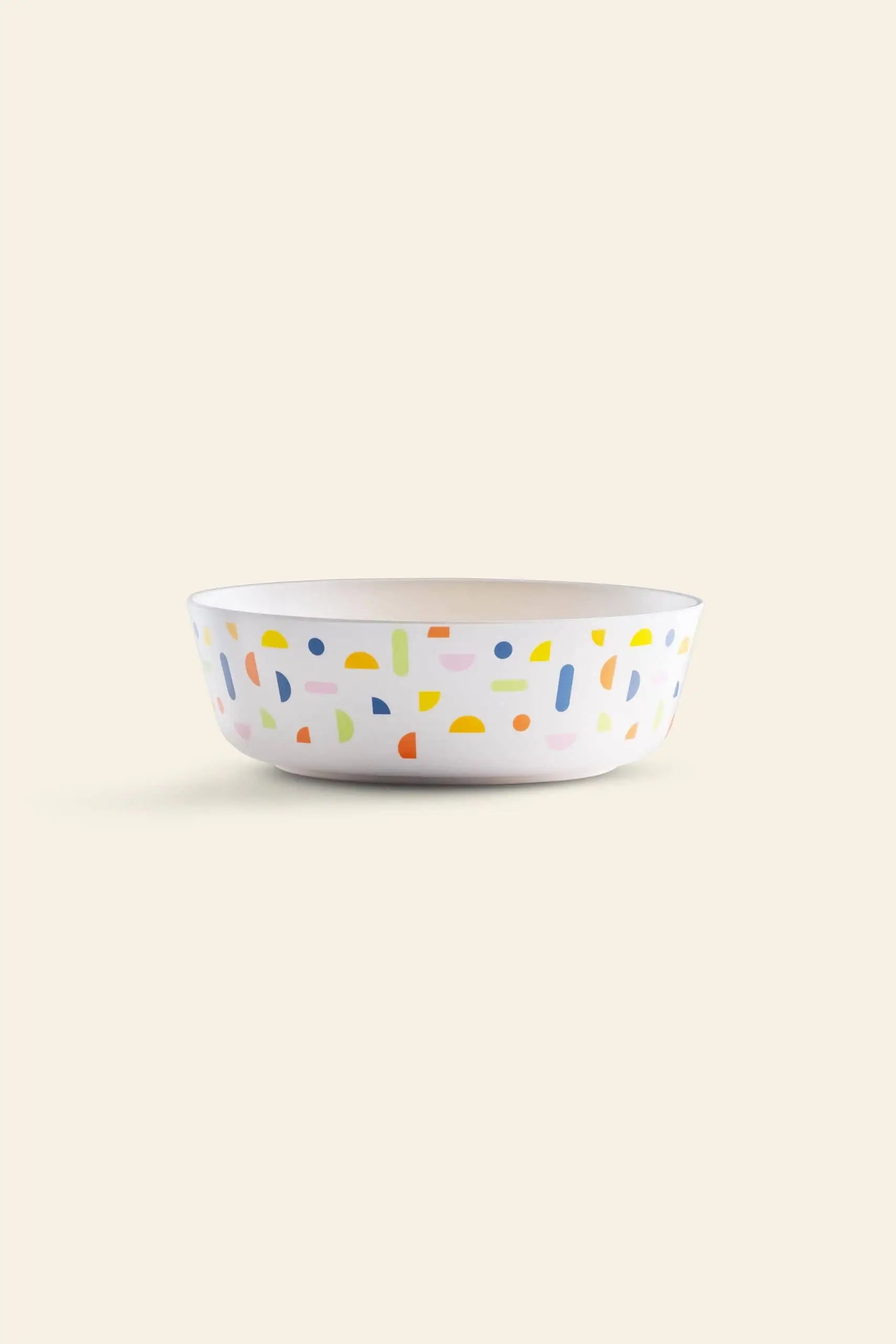 The Poketo Bamboo Bowl by Poketo features playful abstract shapes in yellow, blue, green, pink, and orange on a beige background—a sustainable choice for adding fun to outdoor adventures.