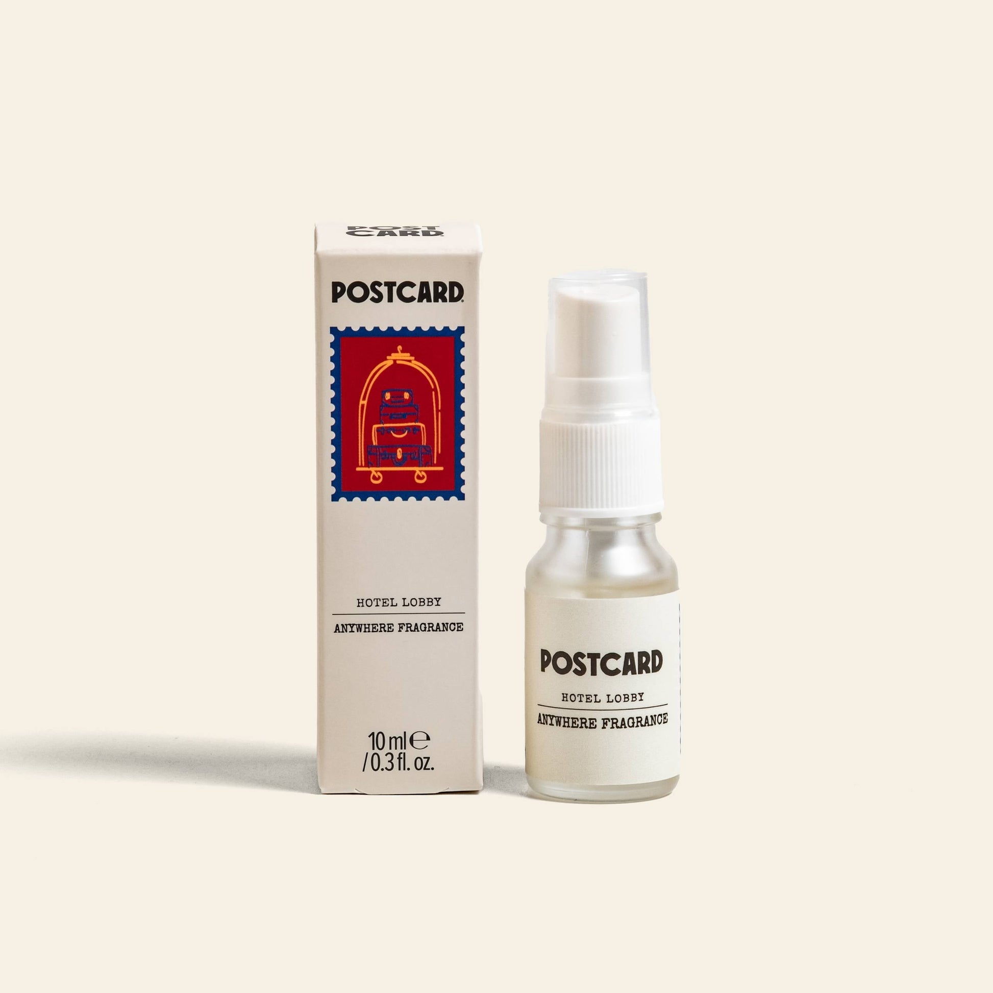 A 10ml bottle of Postcard Anywhere Fragrance – Hotel Lobby by Postcard is placed beside its box, which features a red postage stamp-inspired illustration, all set against a plain light background.