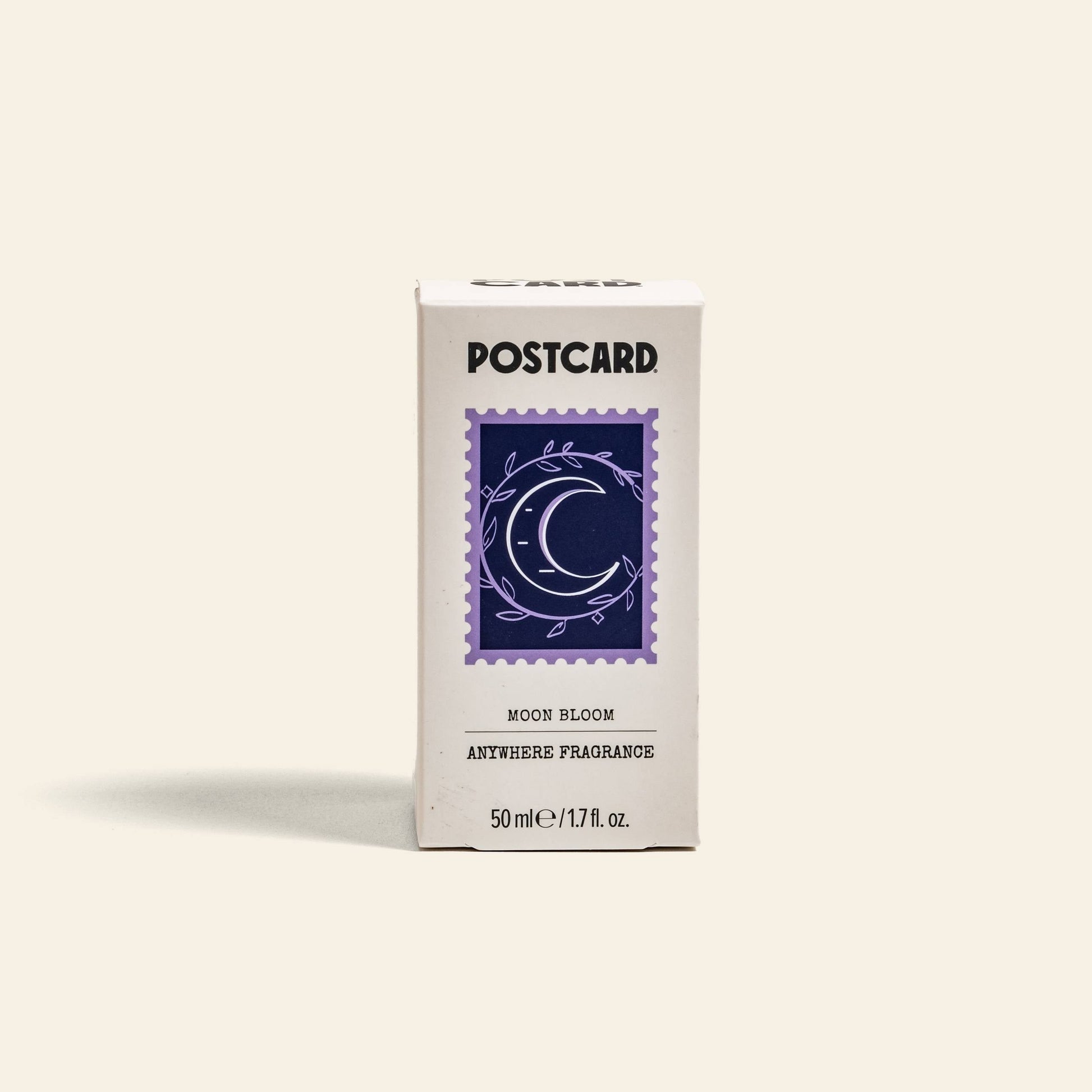 A white Postcard box labeled Postcard Anywhere Fragrance, 50ml - Moon Bloom features a purple crescent moon and leaves stamp design, highlighting the Moon Bloom scent notes.