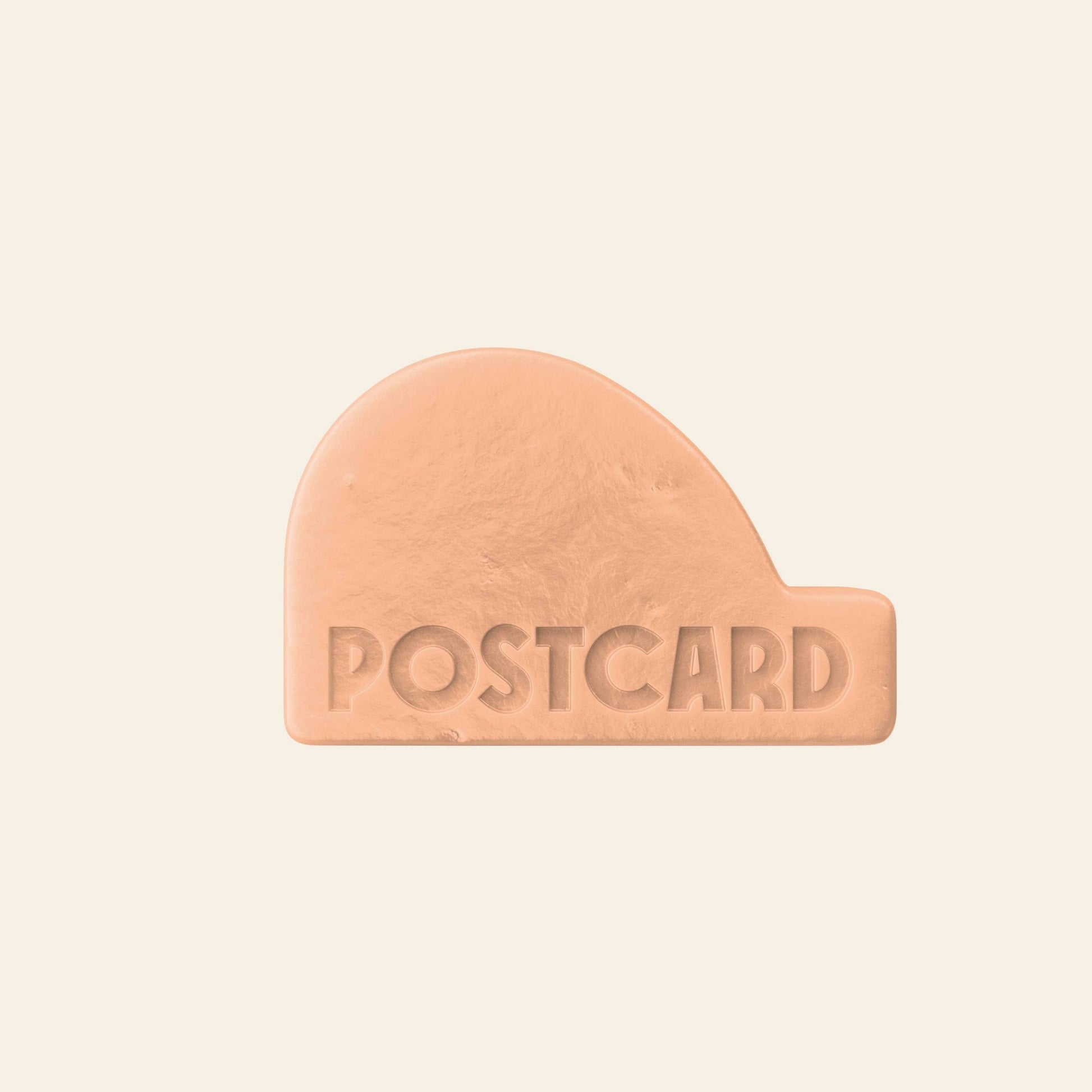 A light brown, abstract-shaped Postcard Head-To-Toe Bar (100g, Citrus Circus), sulfate-free and engraved with POSTCARD, sits against a plain cream background.