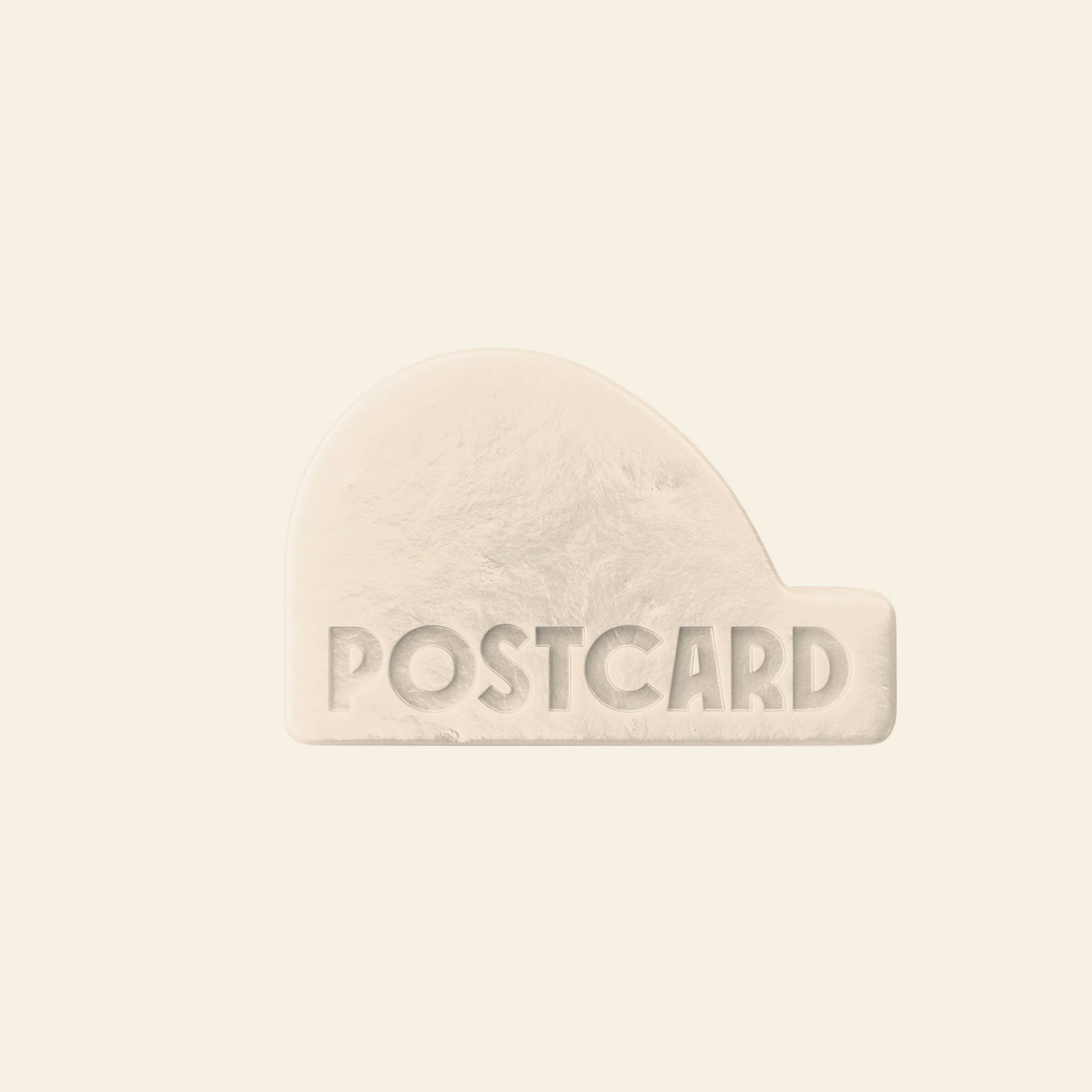 The Postcard Head-To-Toe Bar, 100g - Clear Skies by Postcard features an abstract white design with POSTCARD embossed, set on a light beige background—ideal for gentle cleansing and sensitive skin.