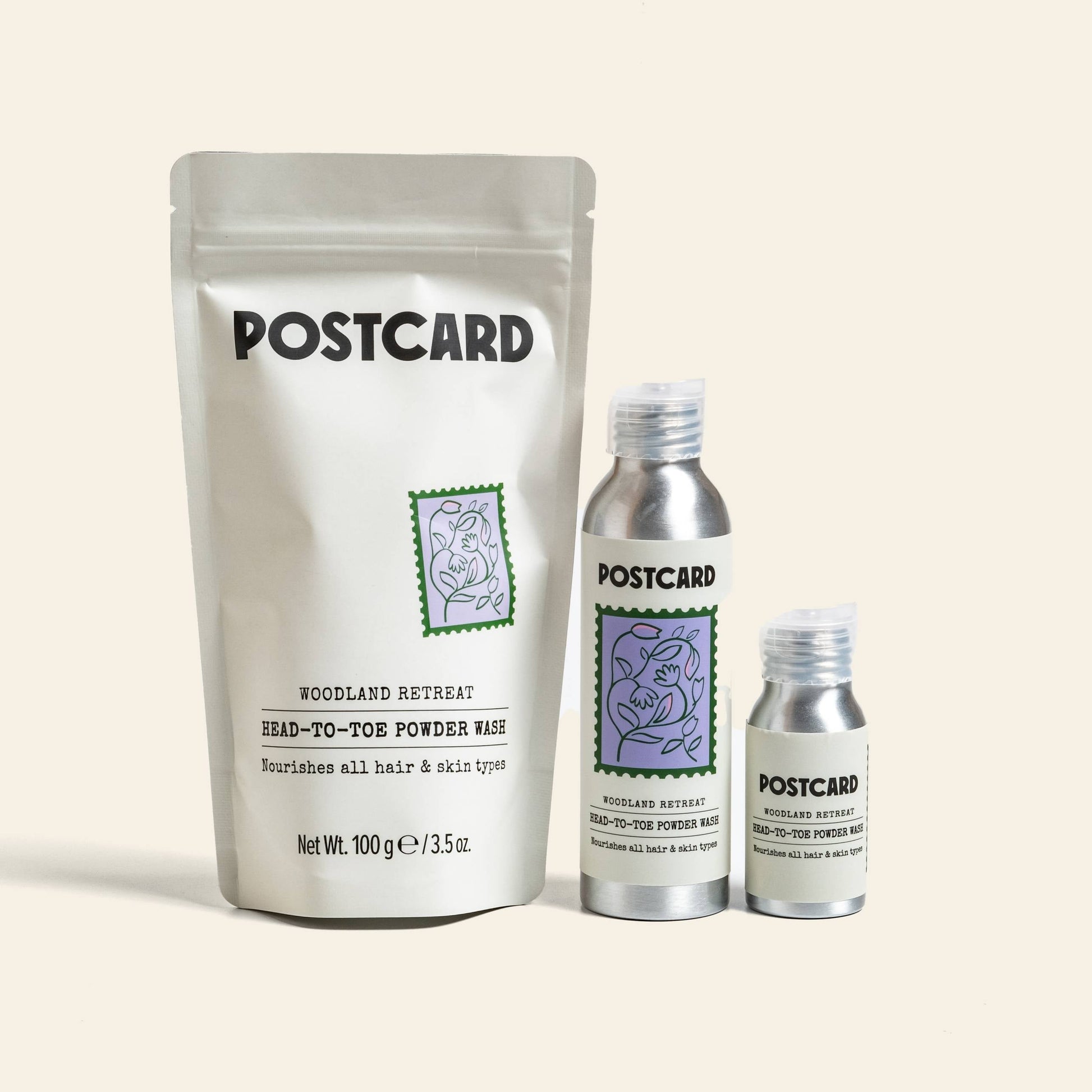 The Postcard Head-To-Toe Powder Wash, 80g - Woodland Retreat features a powder-to-foam cleanser with botanical art and green and purple labels, evoking a relaxing spa vibe.