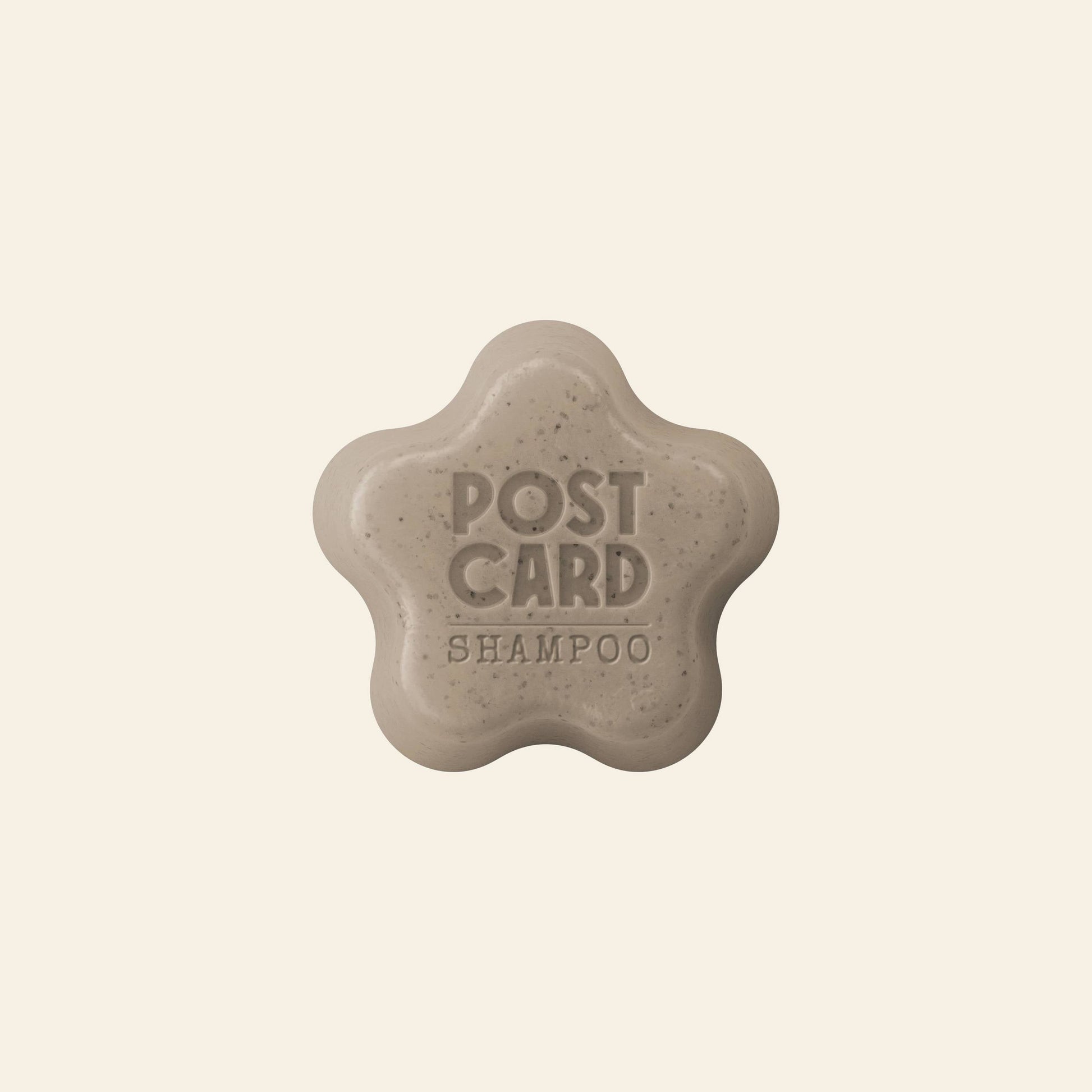 The Postcard Shampoo Bar, 60g - Coffee Spot by Postcard is a beige, star-shaped bar embossed with POST CARD SHAMPOO. Made with upcycled coffee grounds, it helps refresh oily scalps and is shown against a plain light background.