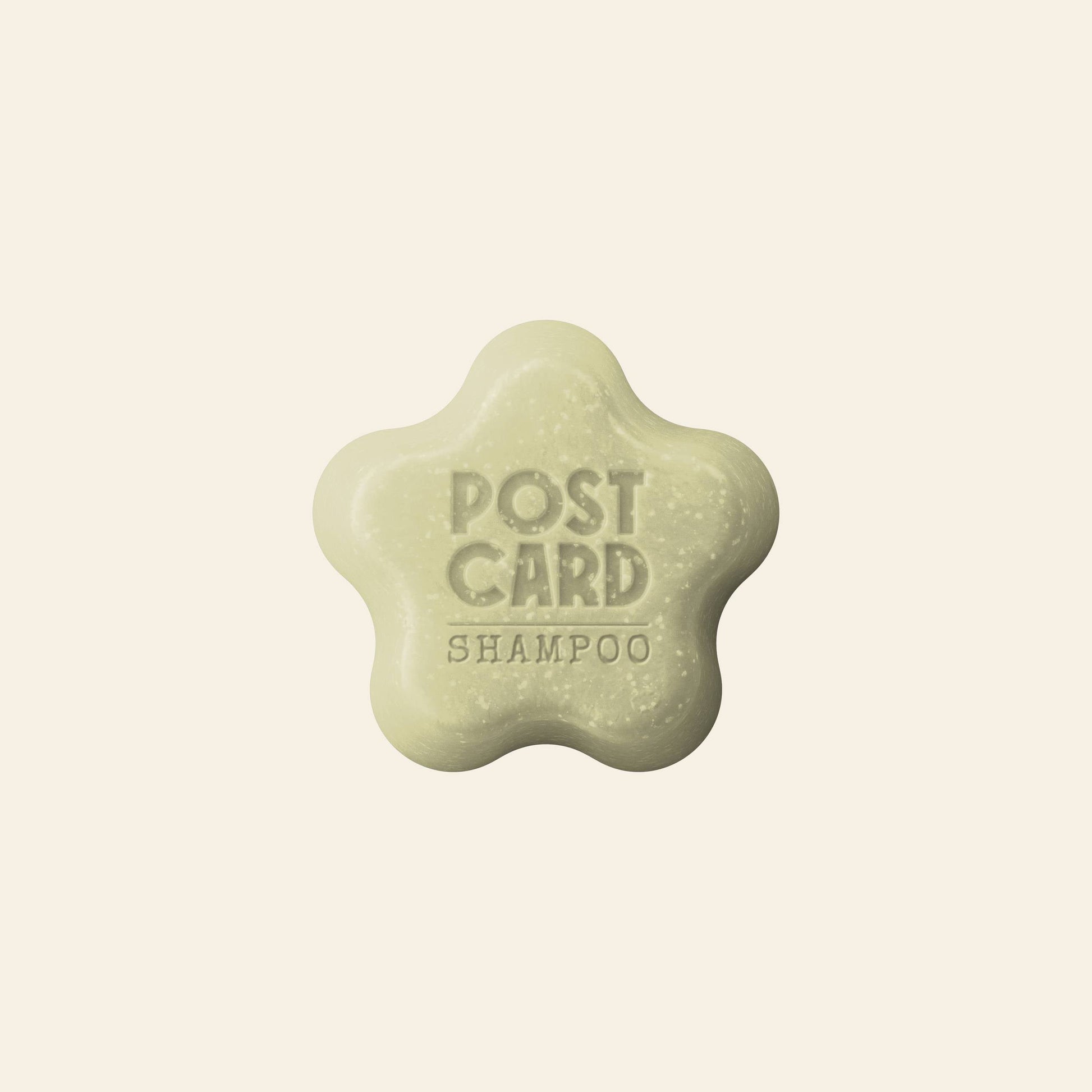 A light green, star-shaped Postcard Shampoo Bar (Java Jungle, 60g), embossed with POST CARD SHAMPOO, sits on a plain off-white background. This sulfate-free bar is by the brand Postcard.