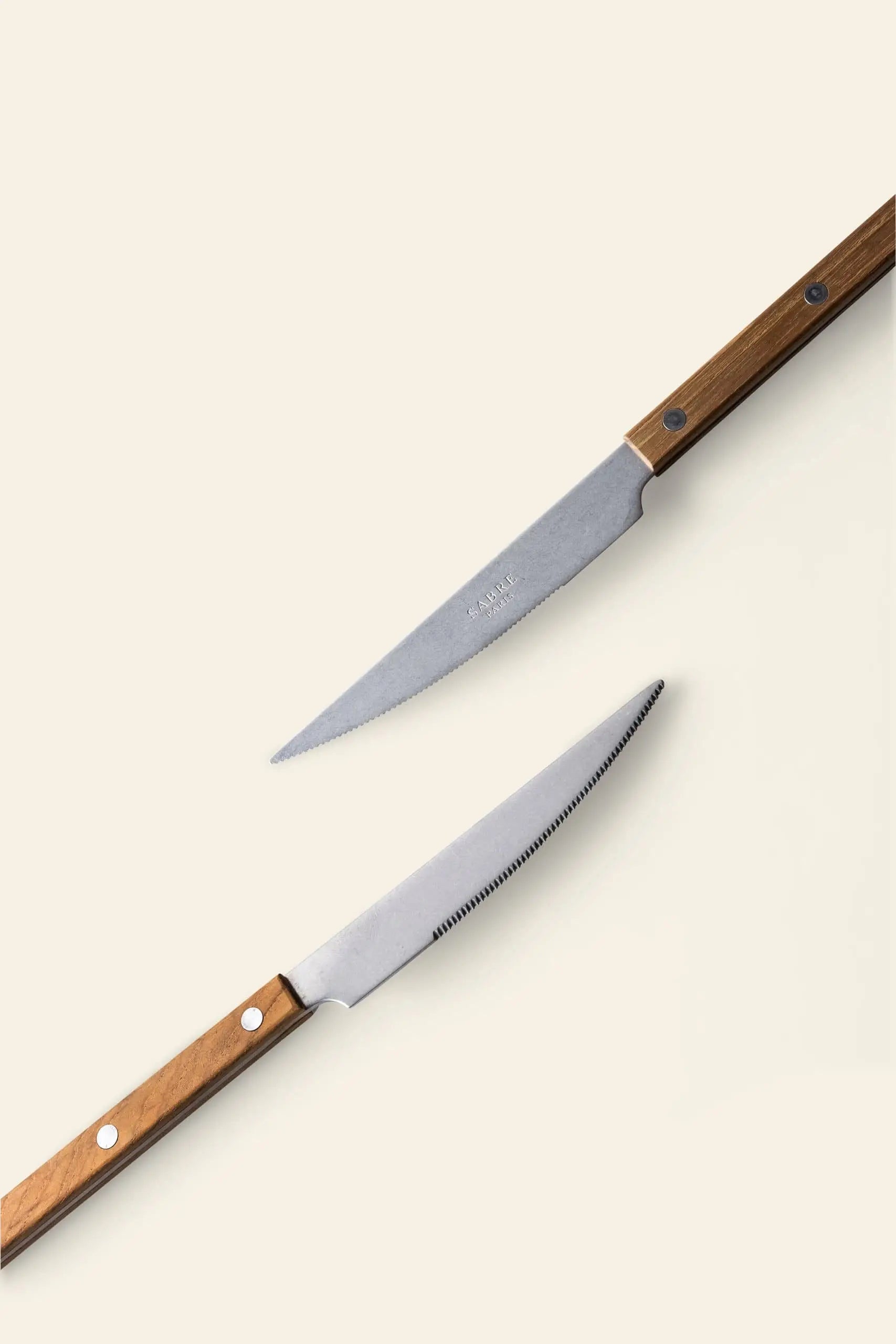 The Sabre Bistrot Vintage Dinner Knife by Sabre features classic French bistrot style with a wooden handle and silver blade, adding vintage charm to your table setting. Smooth and serrated options available.