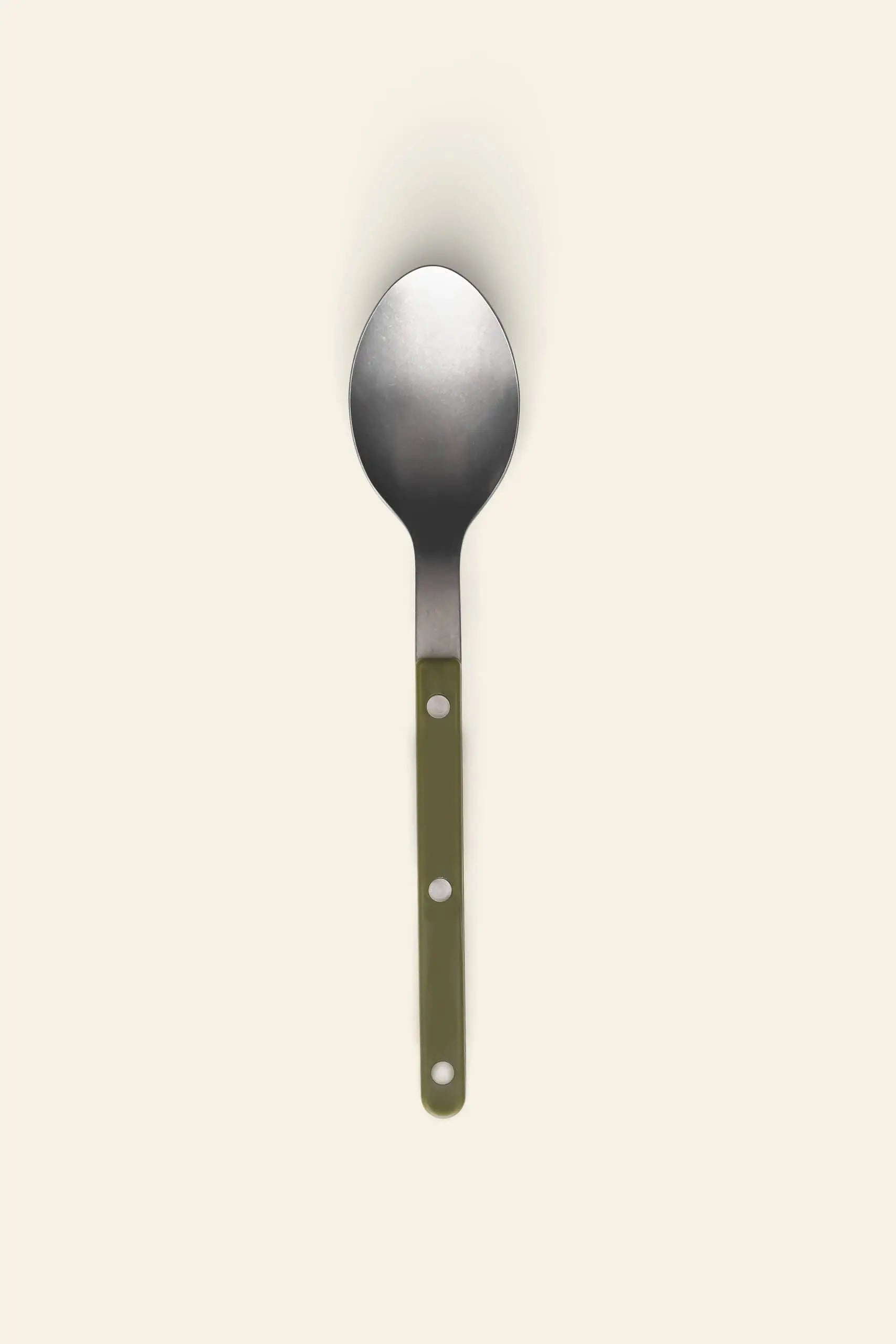 The Sabre Bistrot Vintage Soup Spoon by Sabre, featuring a green handle with two white rivets and stainless steel construction, is centered on a plain beige background.
