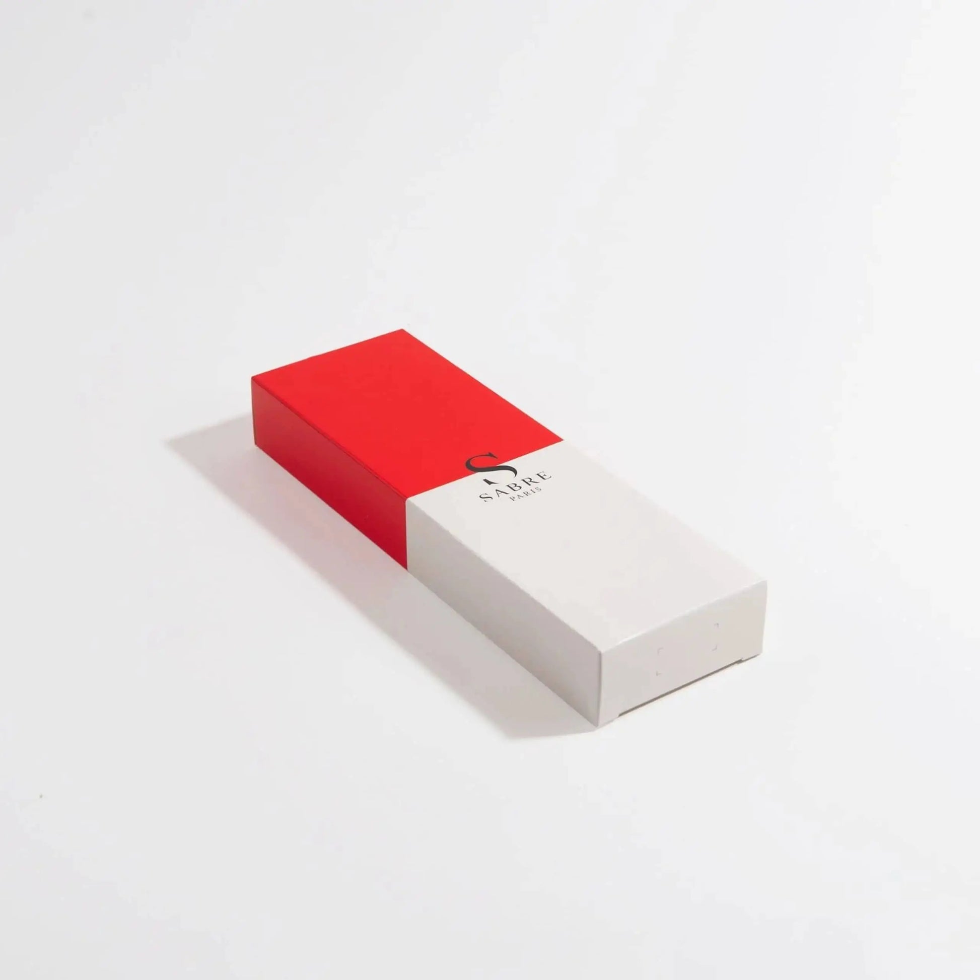 A rectangular box with a red top half and white bottom half, featuring the Sabre logo and Sabre Bistrot Vintage Soup Spoon text, evokes a French cafes charm and sits elegantly against a plain white background.