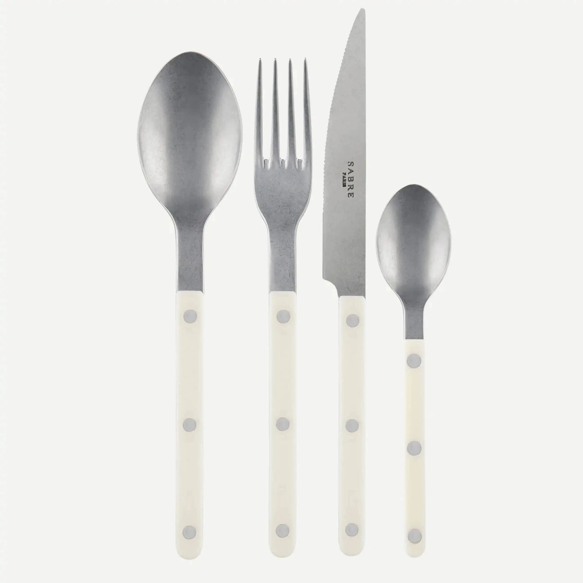 The Sabre Bistrot Vintage Soup Spoon by Sabre is displayed alongside a large spoon, fork, and knife with white handles, all arranged side by side on a plain white background.