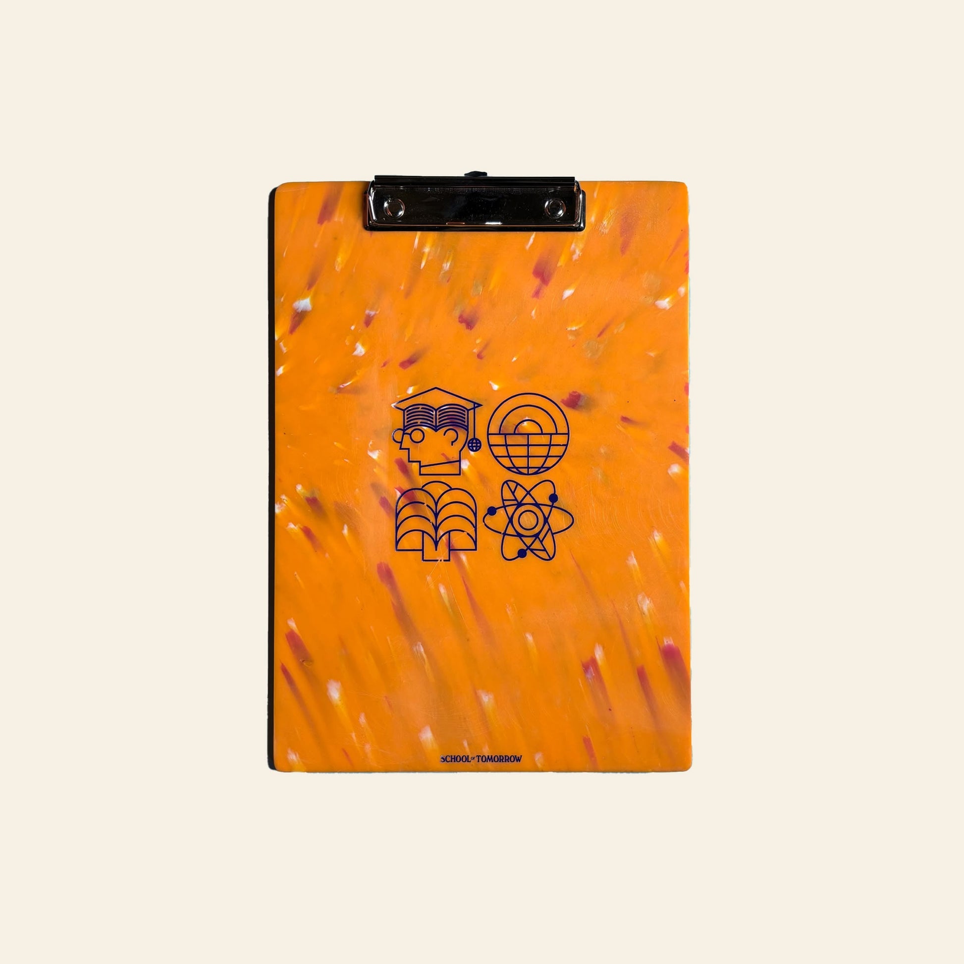 The School of Tomorrow A4 Clipboard - Orange is made from recycled HDPE plastic with a marbled look and four black icons—graduation cap, globe, book, atom—arranged in a grid. Ideal for eco-conscious students at School of Tomorrow.