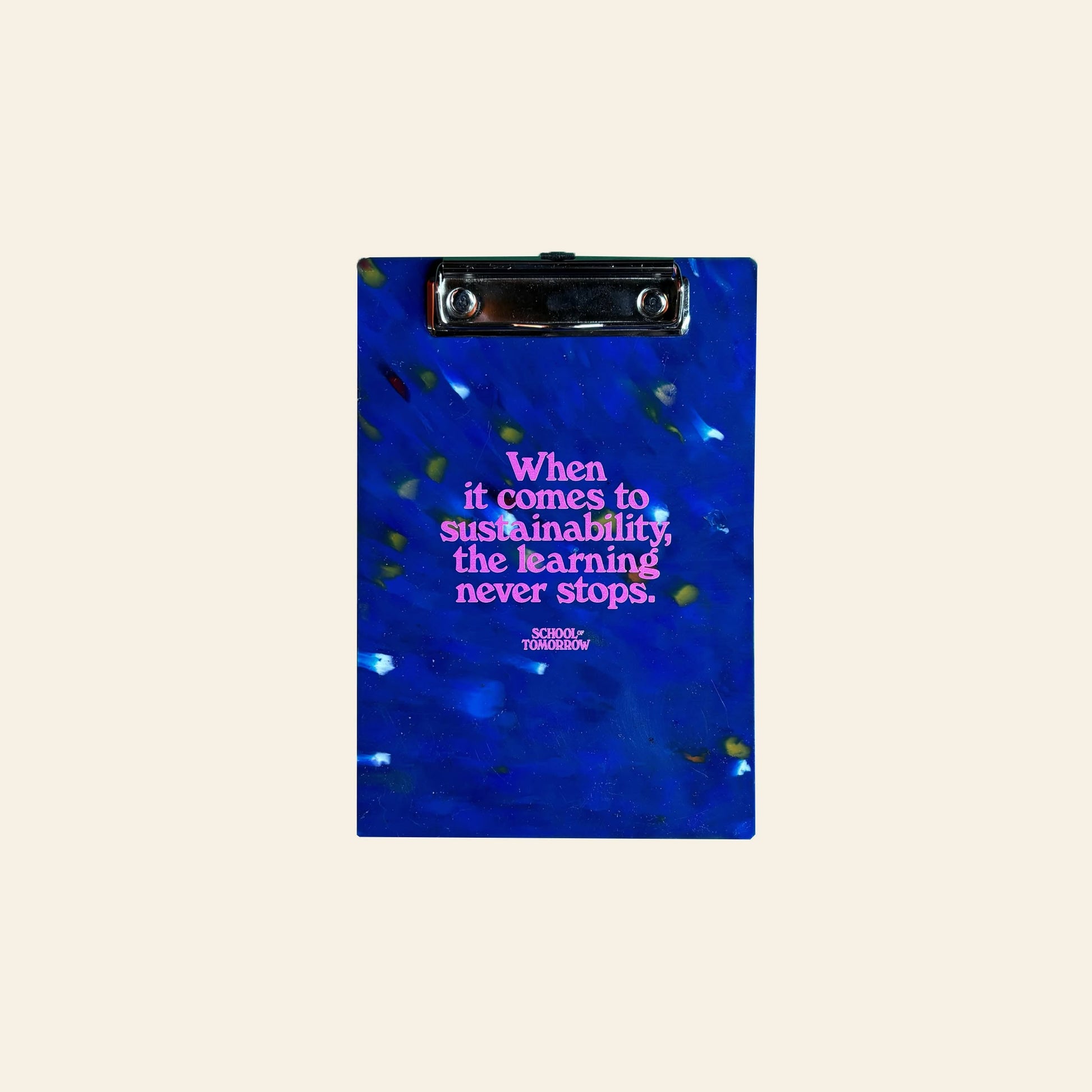 The School of Tomorrow A5 Clipboard – Blue is an eco-friendly clipboard made from high-density polyethylene, with green and yellow speckles and “When it comes to sustainability, the learning never stops. SCHOOL OF TOMORROW” in pink on the front.