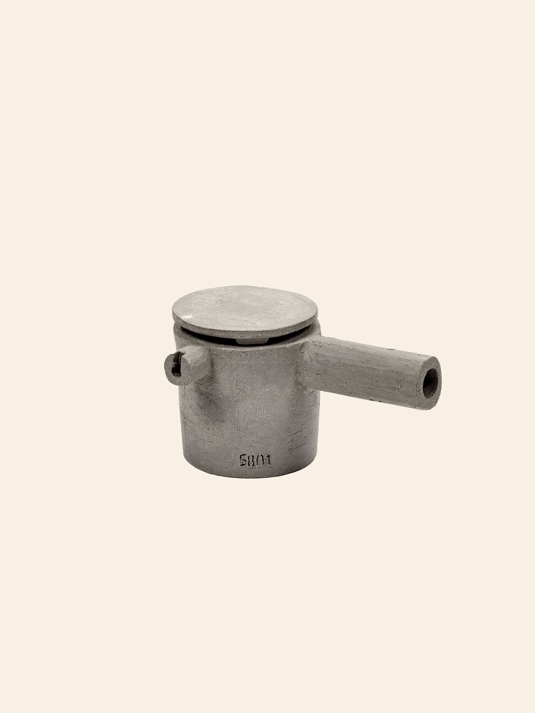 The Serax Fck Teapot N°3 - Grey Brown, by Serax, is a small, cylindrical metal teapot with a flat lid and short spout, highlighting Urbanistic Ceramics style against a plain beige background.