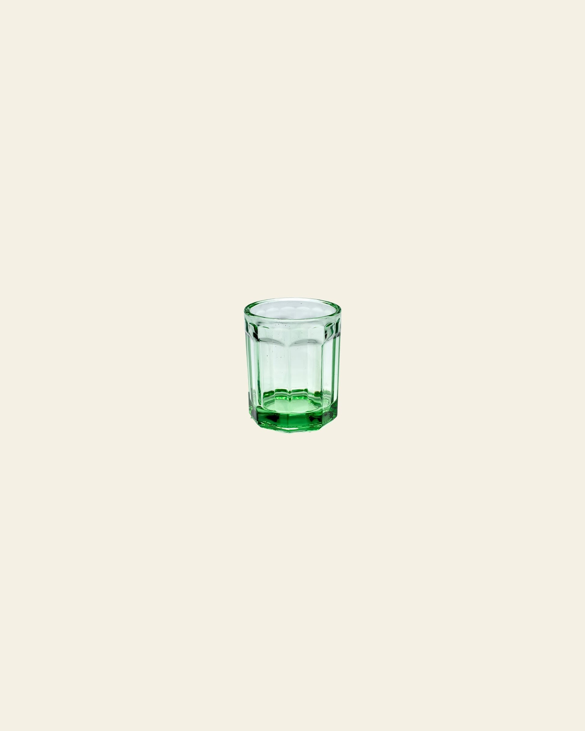A Serax Fish & Fish Glass M - Green by Serax is centered on a plain, light beige background.