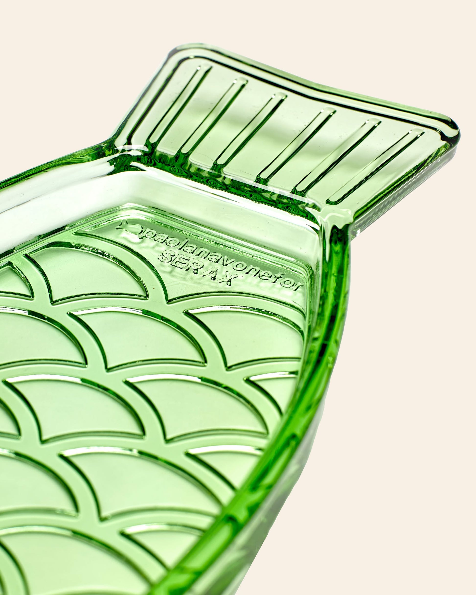 The Serax Fish & Fish Serving Dish N°1 - Green is a glass dish shaped like a fish, featuring a textured scale pattern and “Paola Navone for Serax” embossed on it. Part of the iconic Fish & Fish collection.