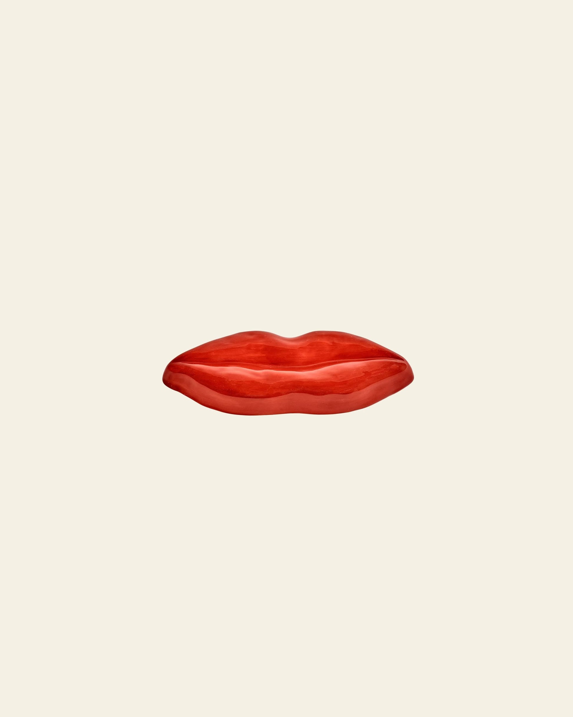 The Serax Les Objets Mouleversants Serving Dish S - Red features glossy, sculpted earthenware lips on an off-white background, evoking pop art style. This decorative dish by Serax adds bold flair to your table or display.