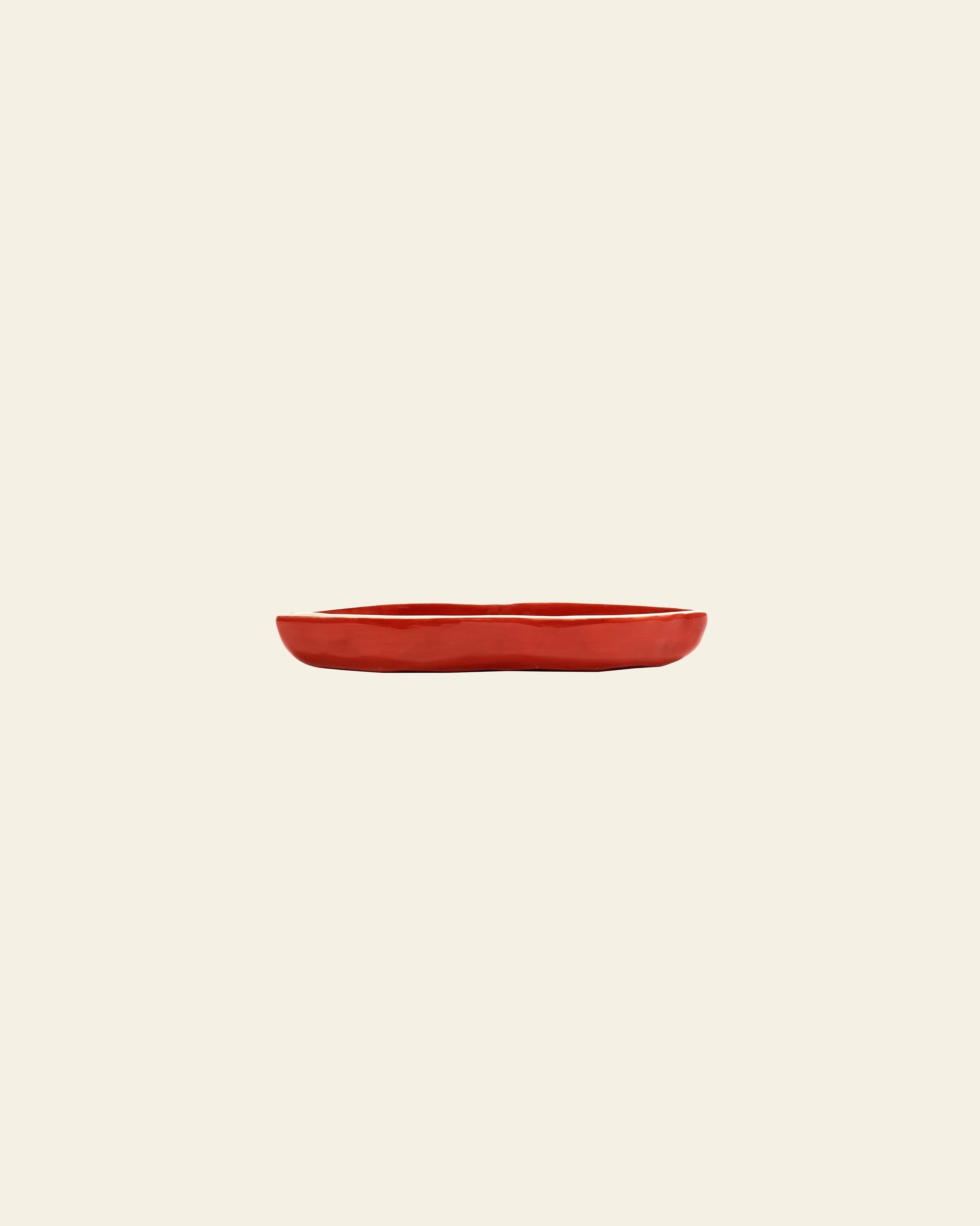 The Serax Les Objets Mouleversants Serving Dish S in red is centered on a plain, light beige background.