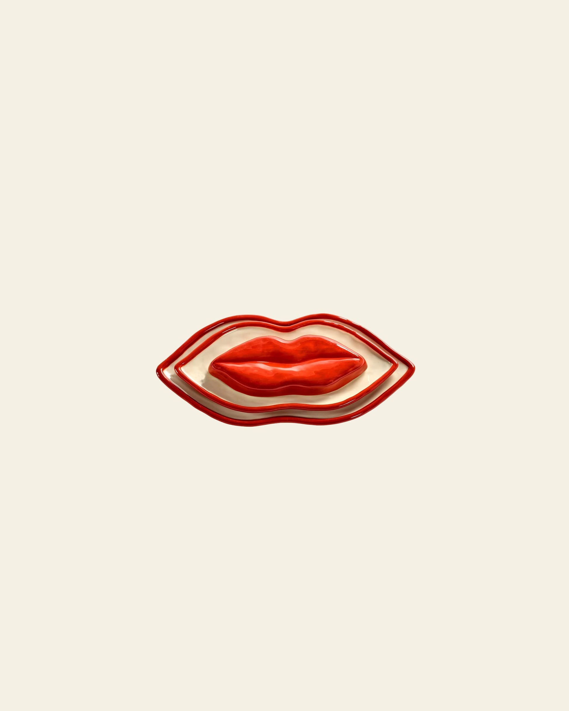The Serax Les Objets Mouleversants Serving Dish S - Red, a ceramic plate shaped like red lips, is showcased on a plain light beige background—an eye-catching piece from Serax.